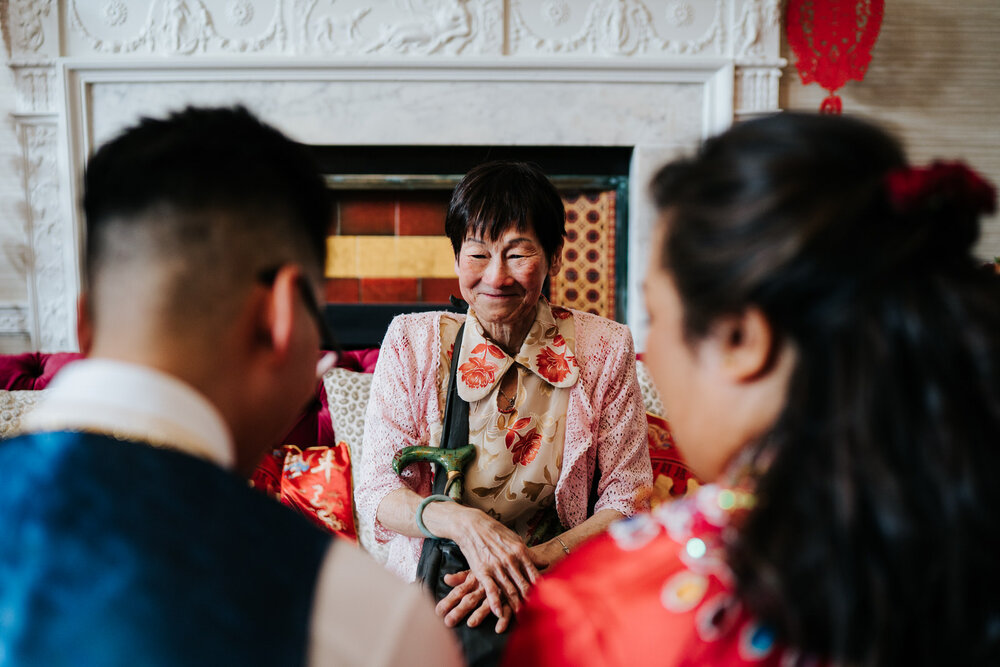 Older family member in front of couple during Chinese Tea Ceremony