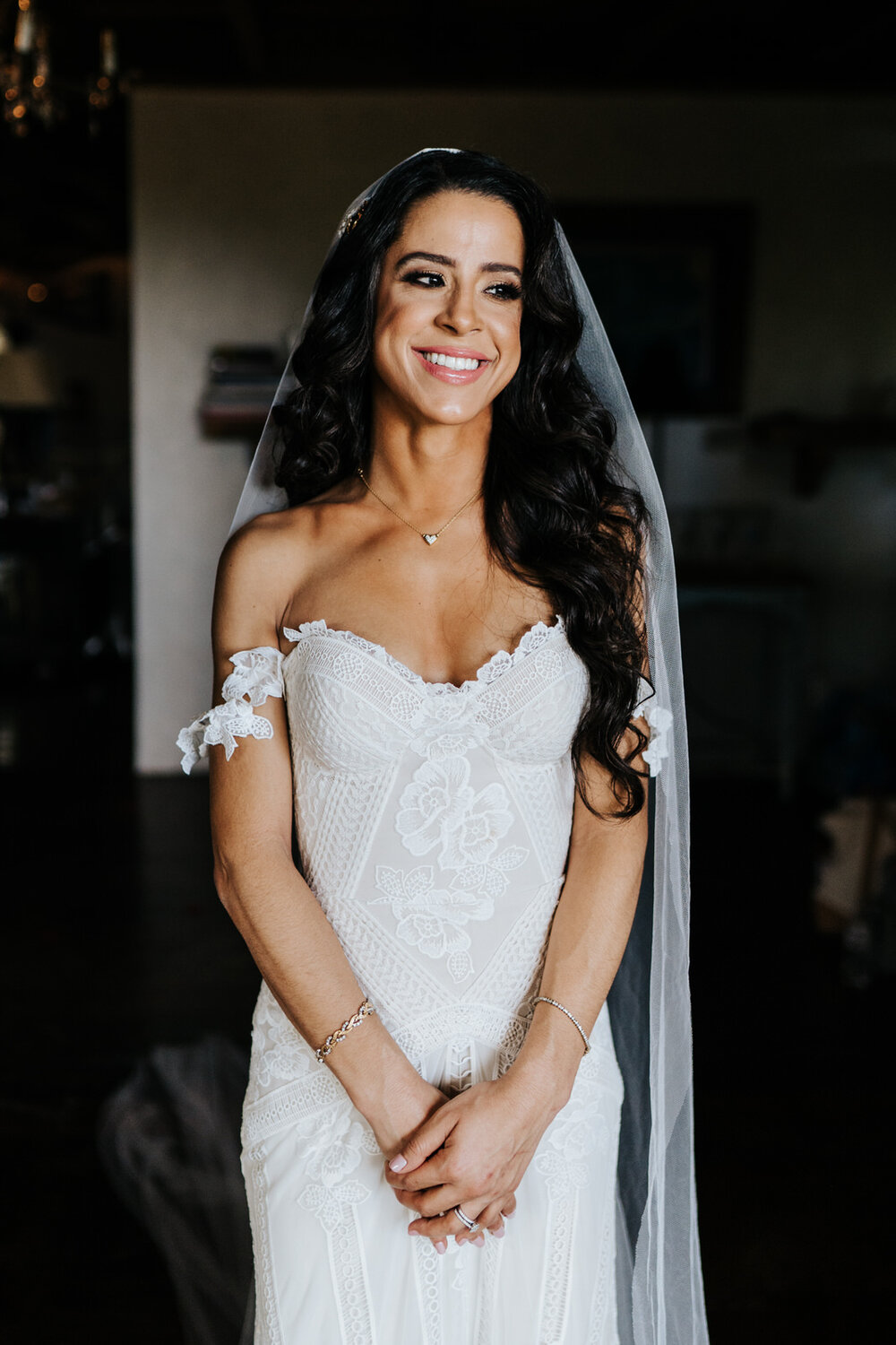 Bride stands in gorgeous, diffused light, hands clasped, smiling (Copy)