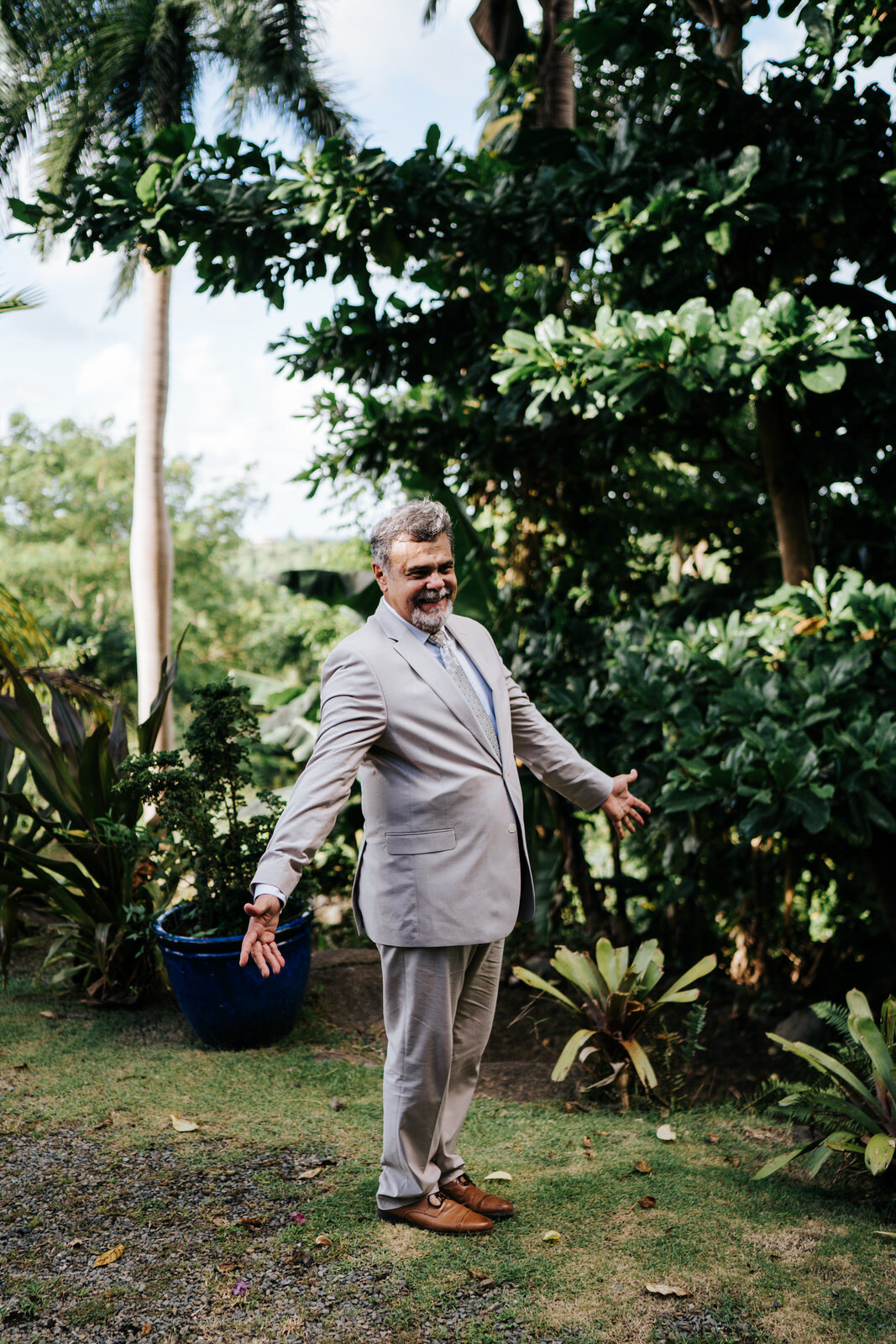 Father of the bride stands outside and opens his arms in surpris (Copy)