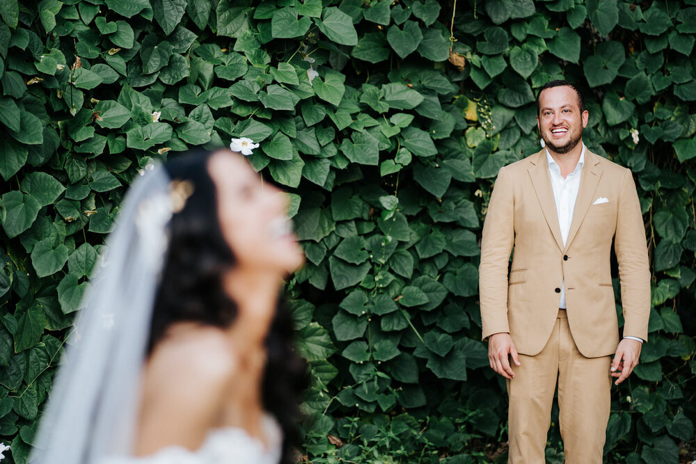 Groom cannot control his smile as he stands in front of lush gre (Copy)
