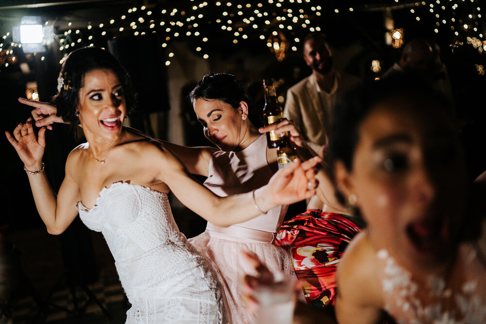 Bride and her friends dance to reggaeton music in slightly tilte (Copy)