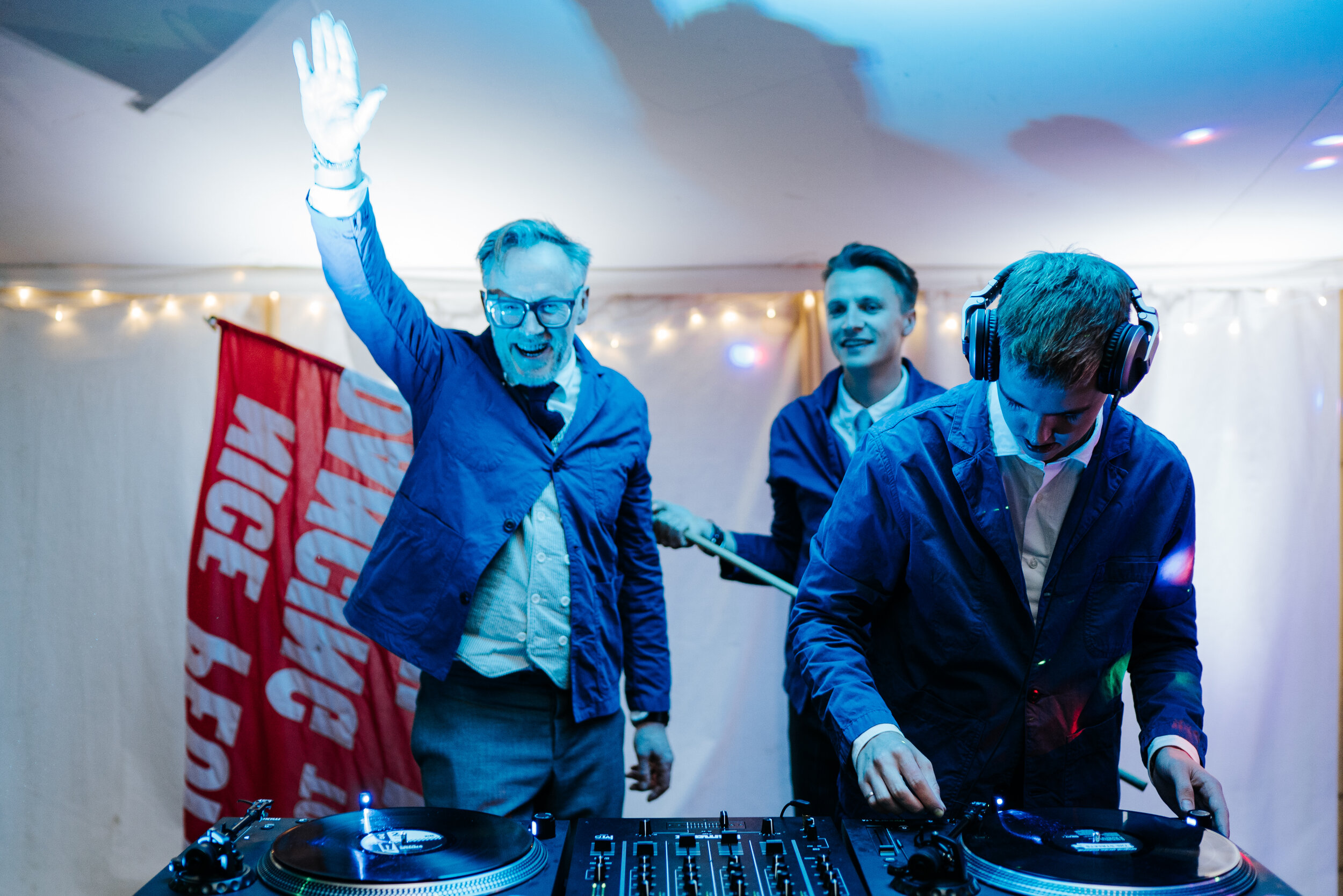 Bride's two brothers and father behind the DJing decks performing as the "Wedding DJs"