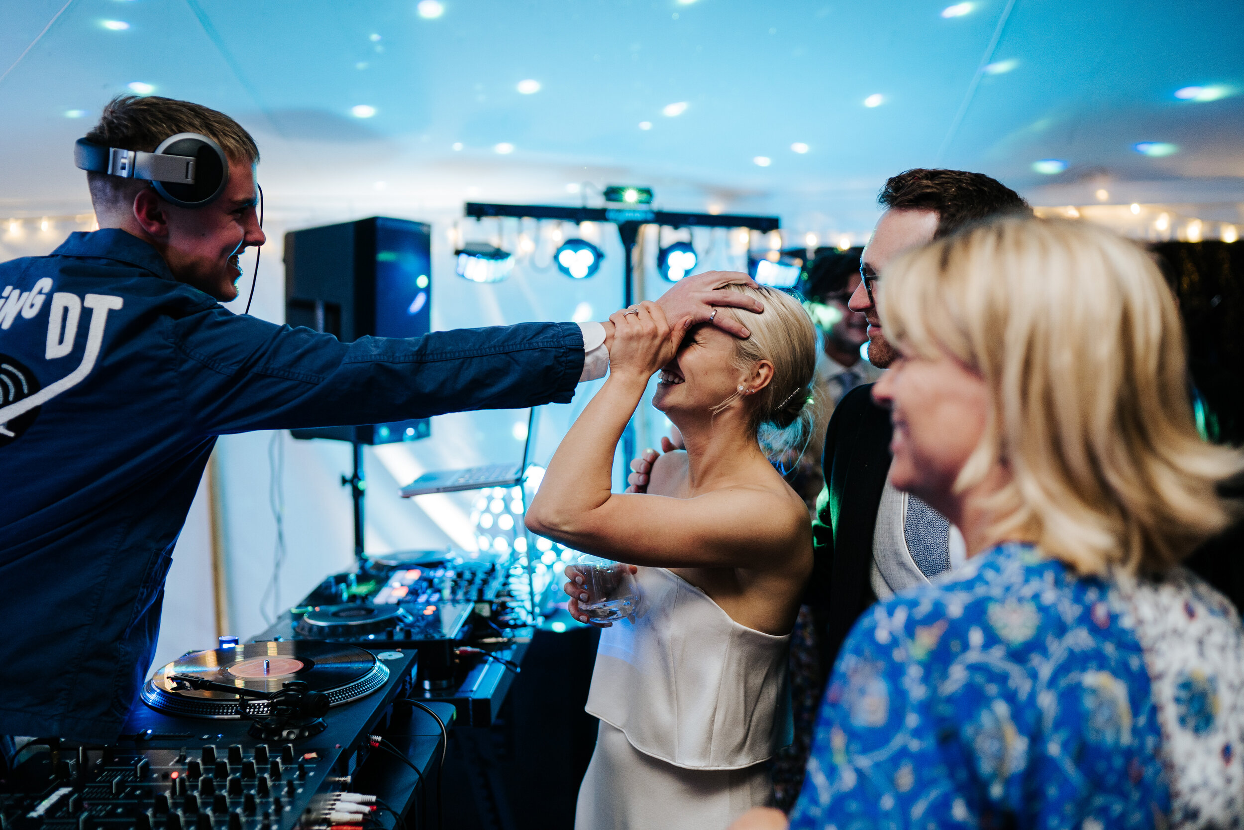 Brother of the bride jokingly grabs bride's head and smiles while doing it