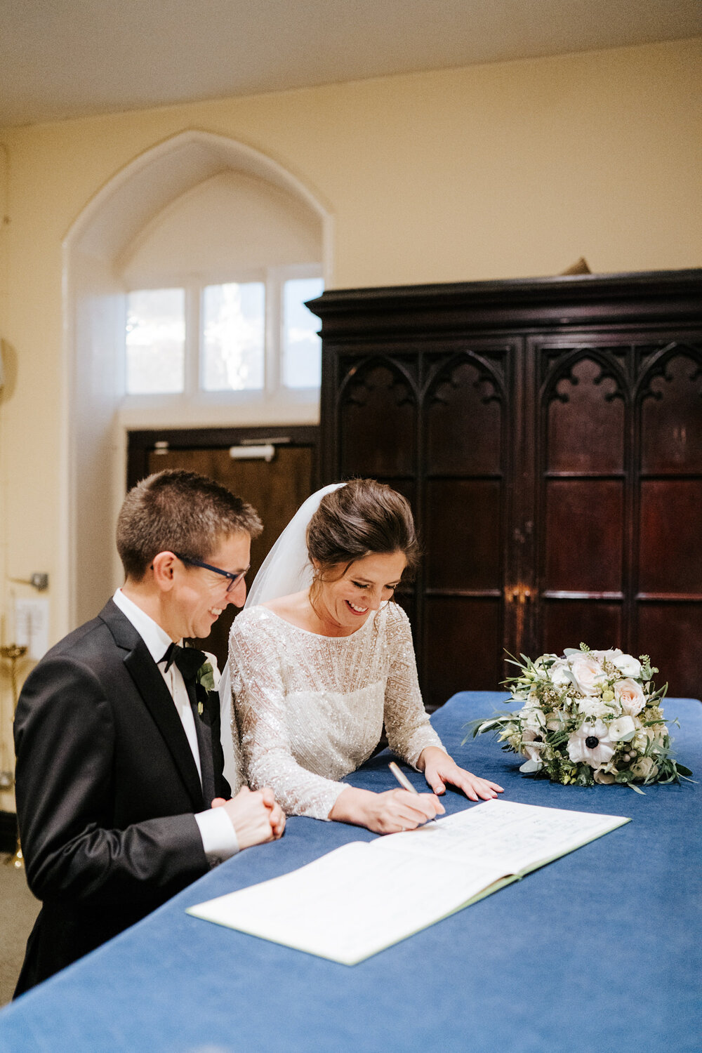 Bride and groom sign the register during wedding ceremony at St Pauls Knightsbridge