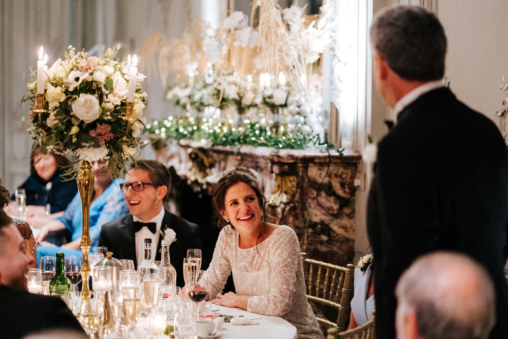 Bride and groom react with laughter to father of the bride's speech