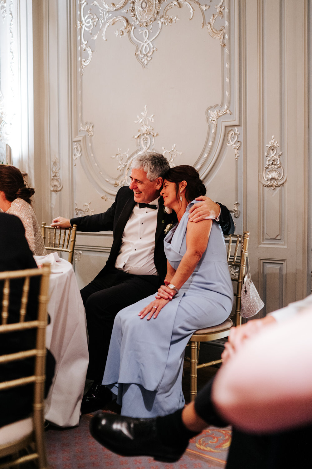Mother and father of the bride share a tender moment and embrace during wedding speeches