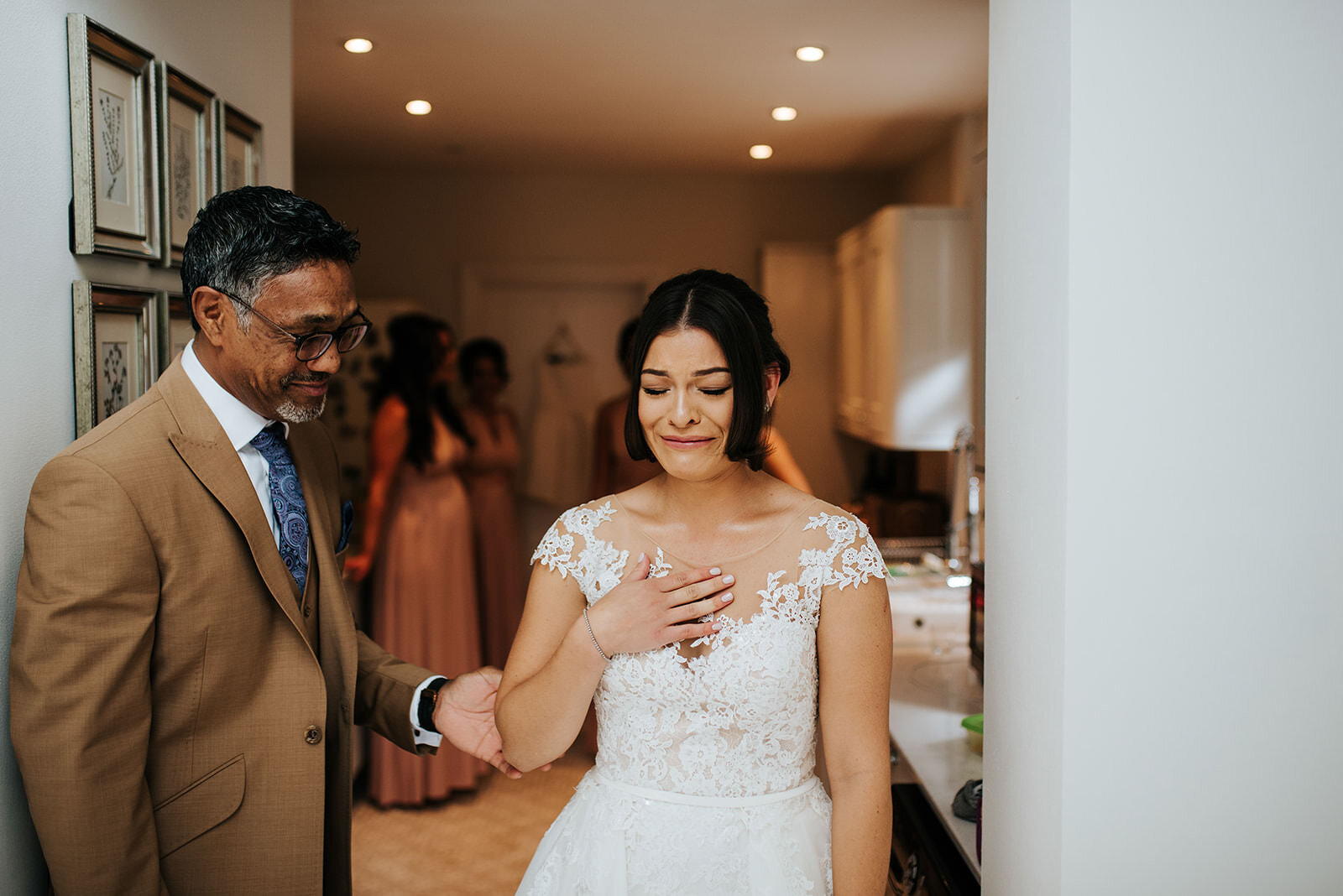 Father of the bride touches the bride's arm and shares a moment with her before departing for the wedding ceremony 