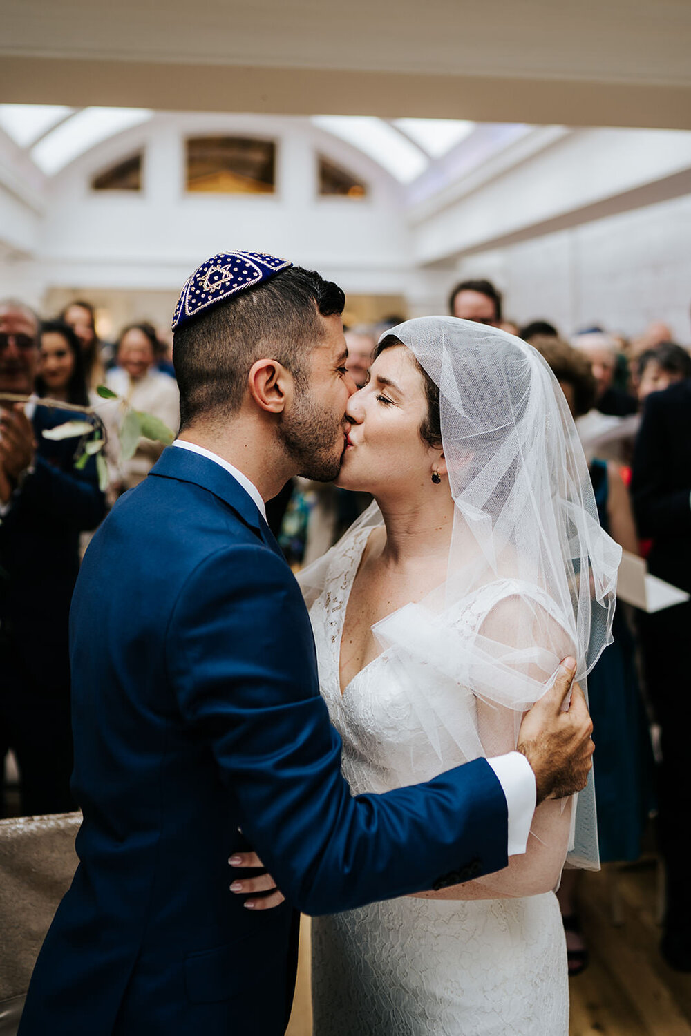 Bride and groom share a first kiss during Jewish wedding ceremony at Pembroke Lodge Wedding in Richmond, London