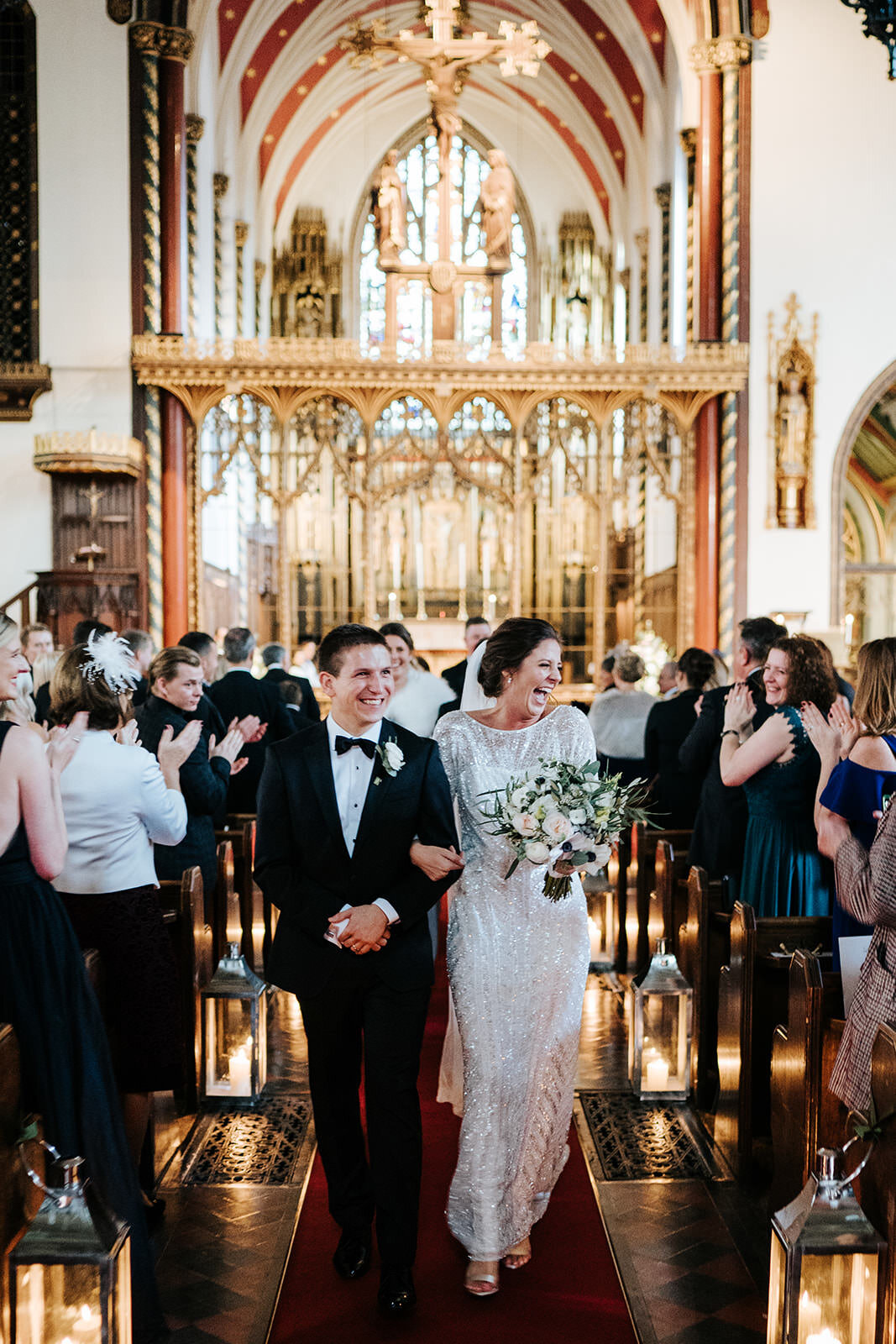 Bride and groom, dressed elegantly, walk back down the aisle after ceremony in St Pauls cathedral Knightsbridge