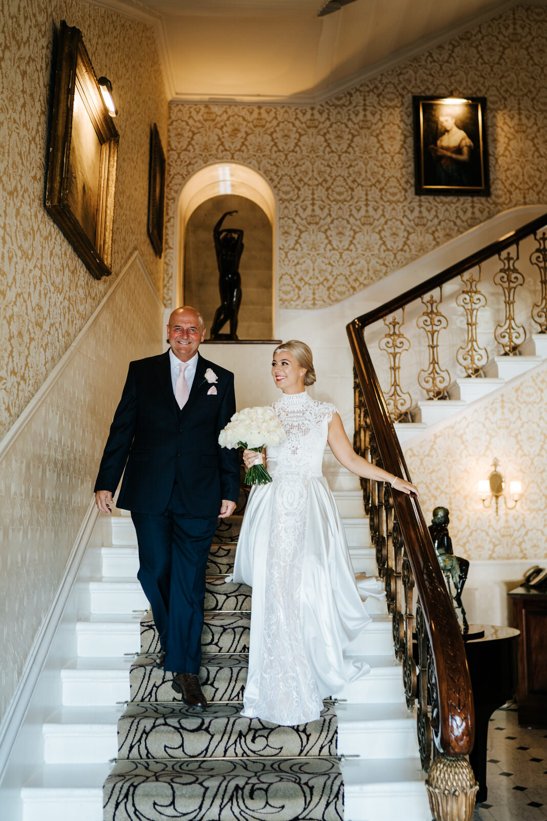 Father of the bride and bride walk down the stairs at The Petersham in Richmond as they leave for wedding ceremony