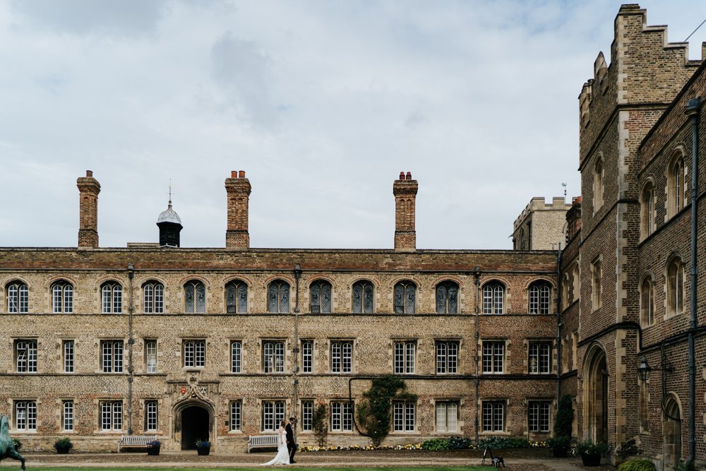 Wide photograph of Jesus College, Cambridge University wedding architecture as bride and groom make their way to their wedding ceremony
