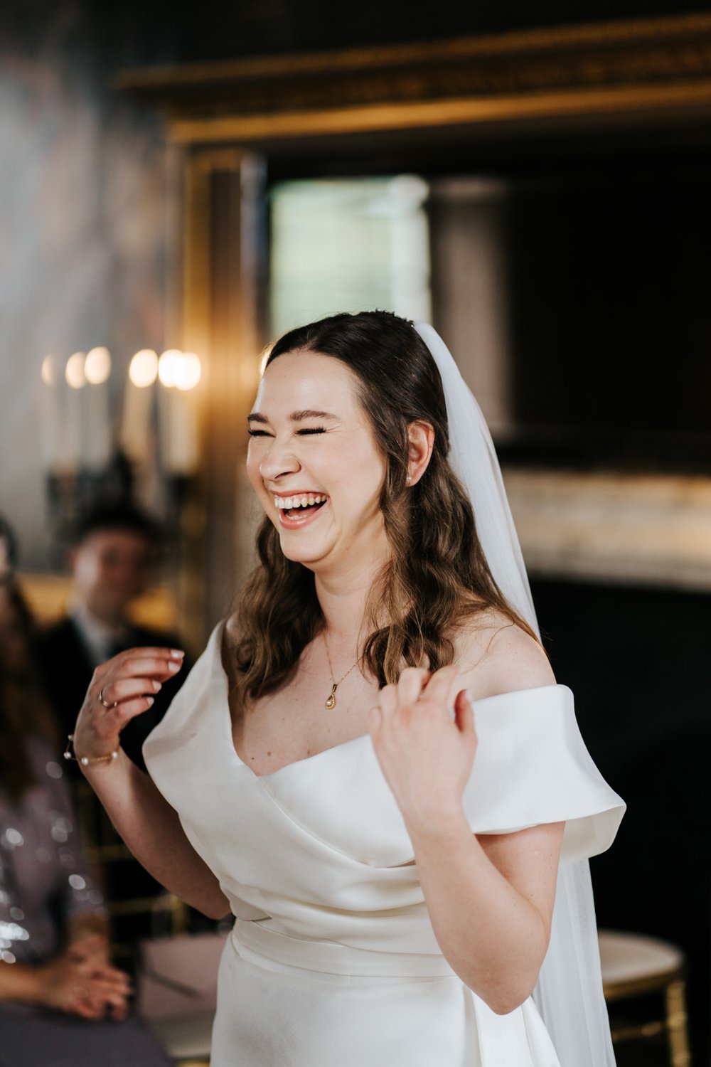 Bride smiles and cannot contain her excitement during Little Banqueting House, Hampton Court Palace wedding ceremony while wearing Eva Lendel wedding gown