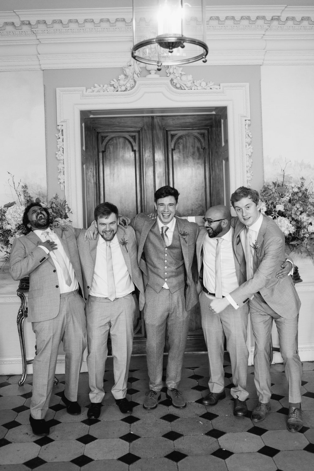 Ed Gamble, groom, stands with his groomsmen in wedding photograph taken at Hedsor House