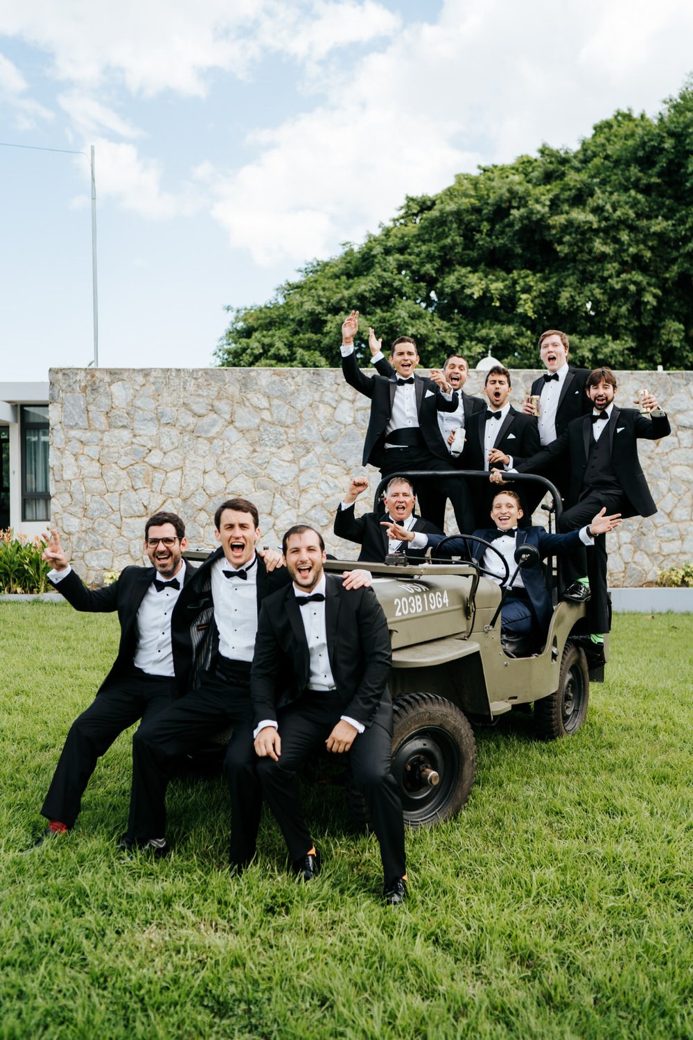 Groomsmen pose in military jeep before departing for Puerto Rico wedding
