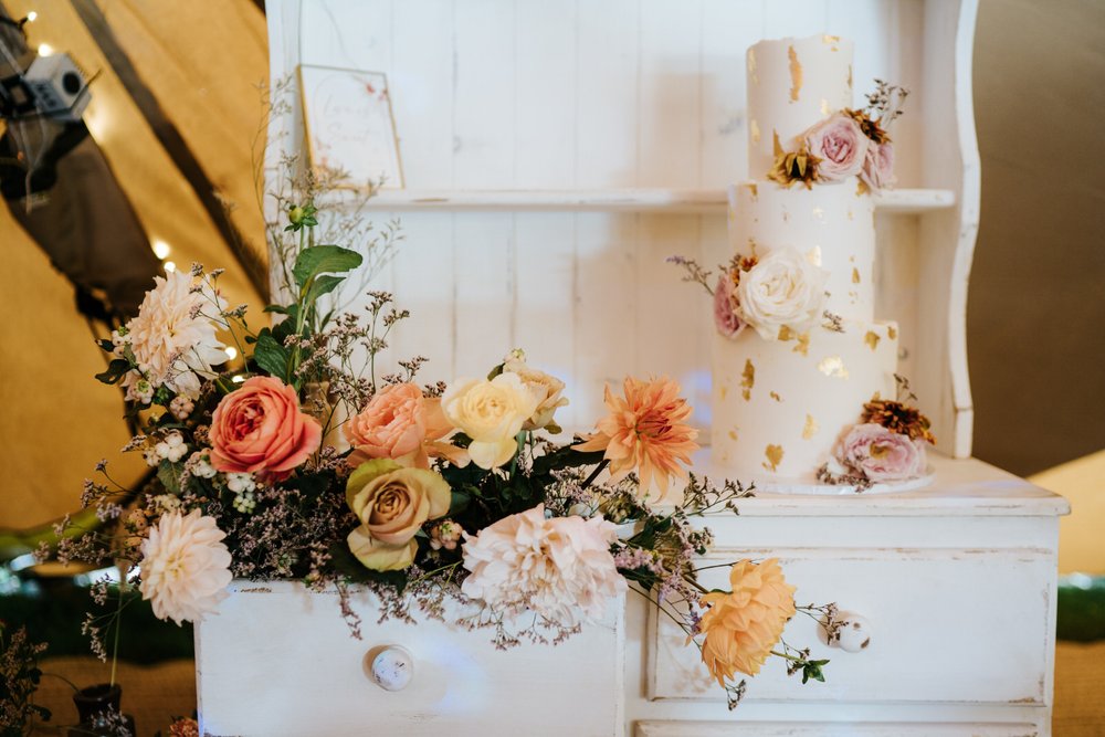 Wedding cake alongside wedding flowers by Leigh Chappell
