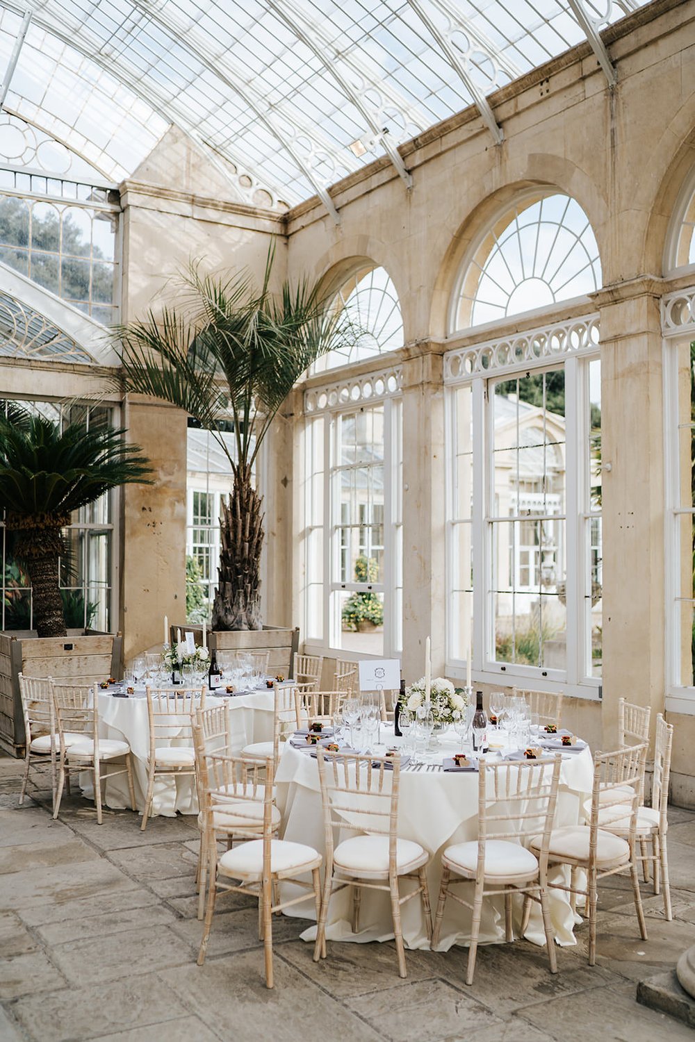 Wide photograph of wedding decoration at Syon Park with a focus on elegant, white florals provided by Louise Dutfield flowers