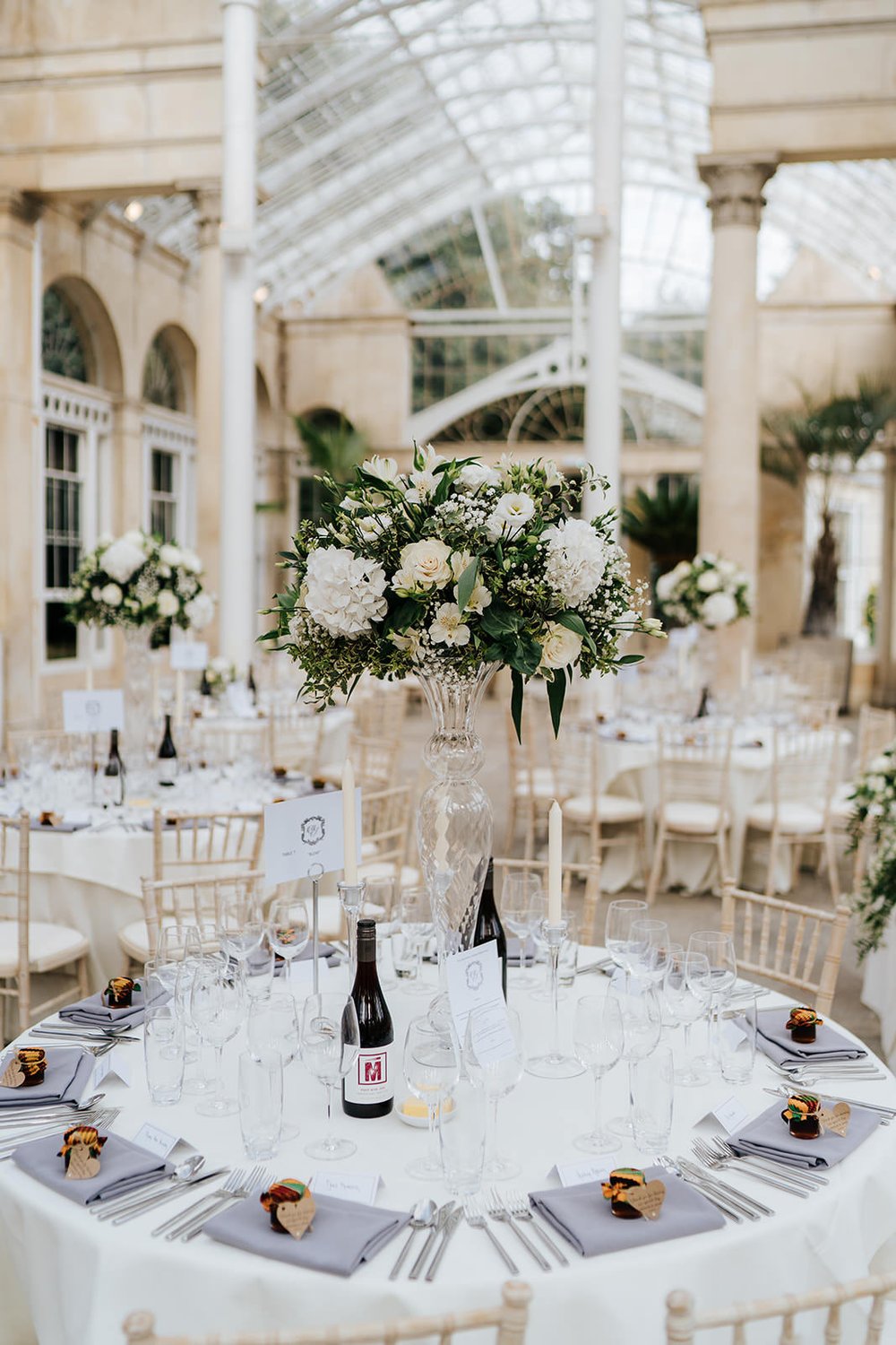 Wide photograph of wedding decoration at Syon Park with a focus on elegant, white florals provided by Louise Dutfield Flowers