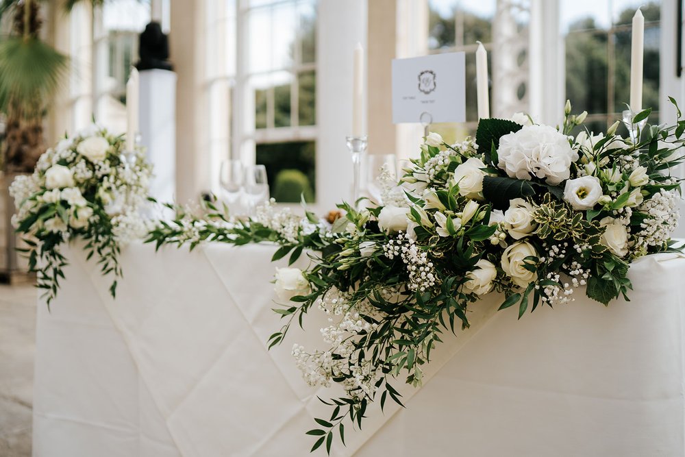 Close-up of head table at Syon Park decorated elegantly by Louise Dutfield in white flowers and green foliage