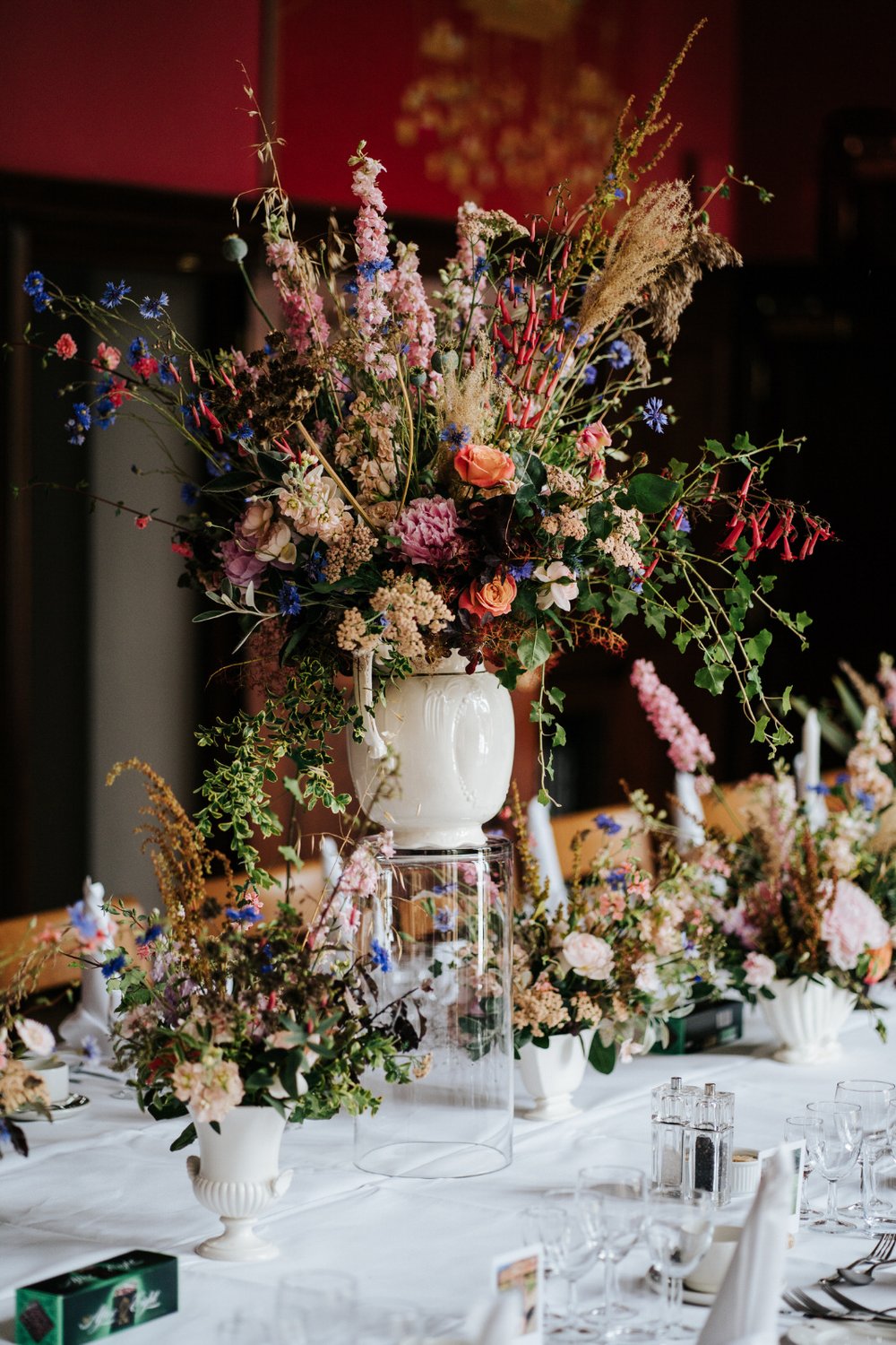 Vase full of colourful and rustic flowers on top of head table at Jesus College in Cambridge 