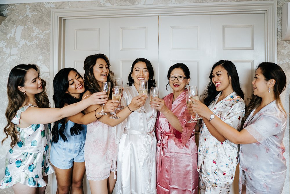 Bride and bridesmaids toast with champagne before leaving Harbour Hill Hotel for wedding ceremony