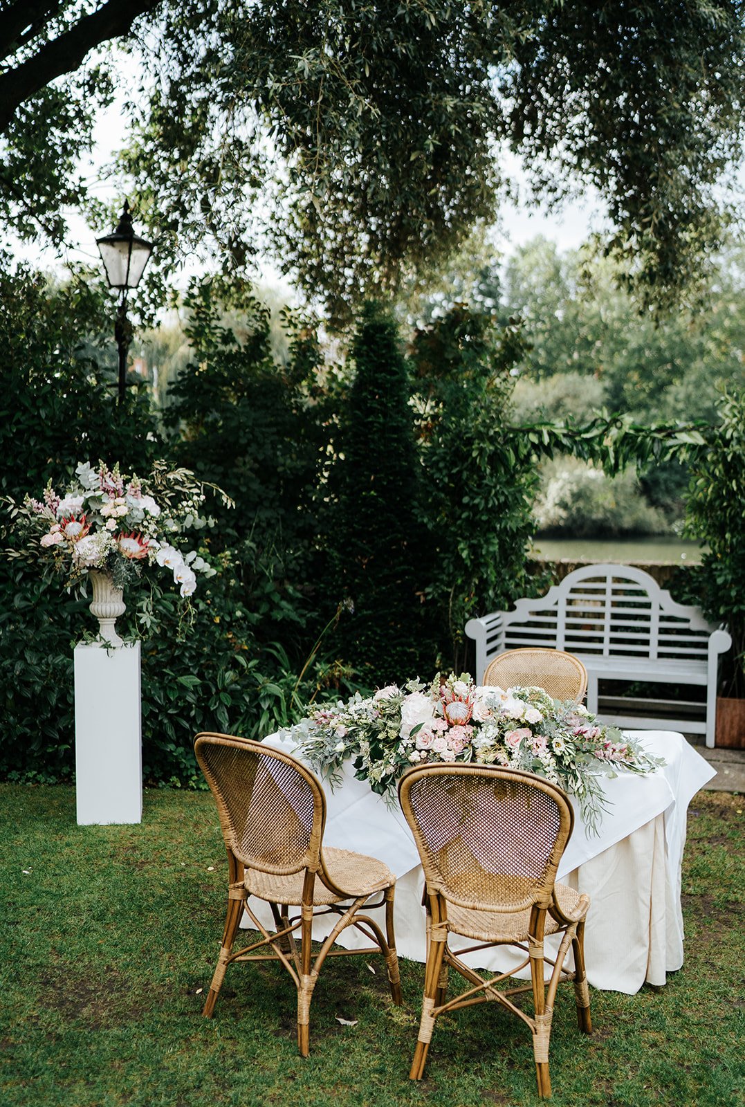 Gorgeous outdoor wedding setup at Bingham Riverhouse with rattan chairs and flowers in vase