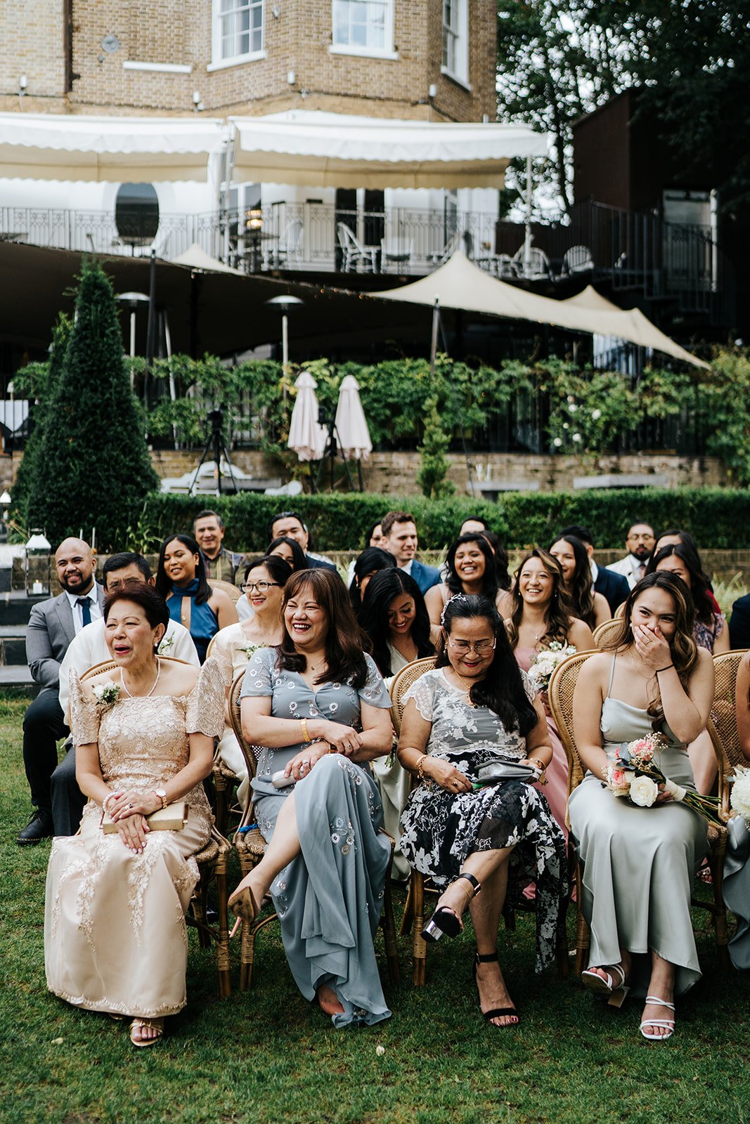 Candid photograph of guests listening to the bride and groom exchange vows at Bingham Riverhouse wedding