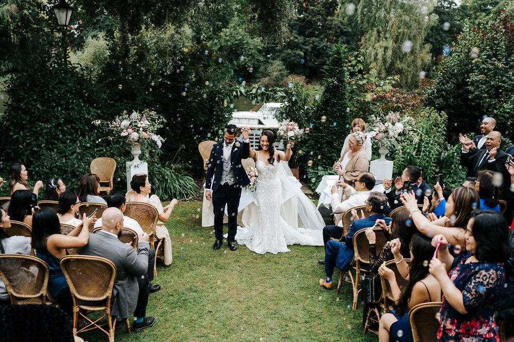 Bride and groom walk back down the aisle as newly married couple 