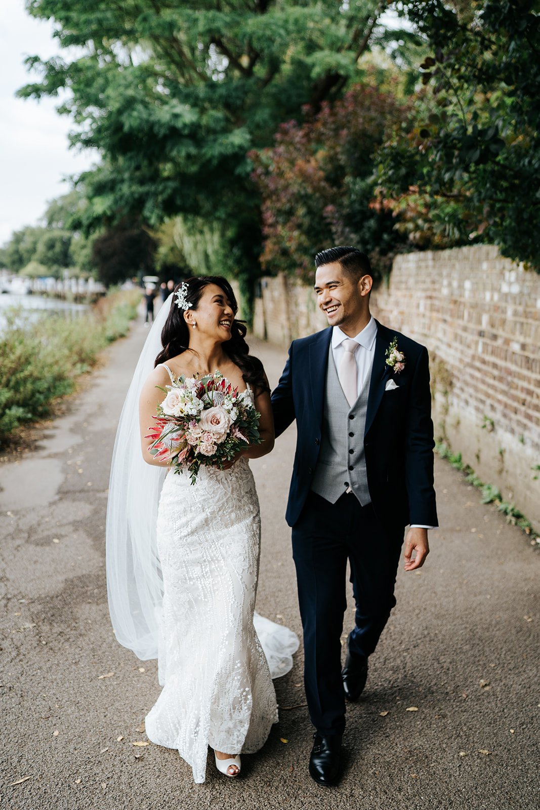 Bride and groom walk down the river Thames path outside of Bingham Riverhouse for a few photos