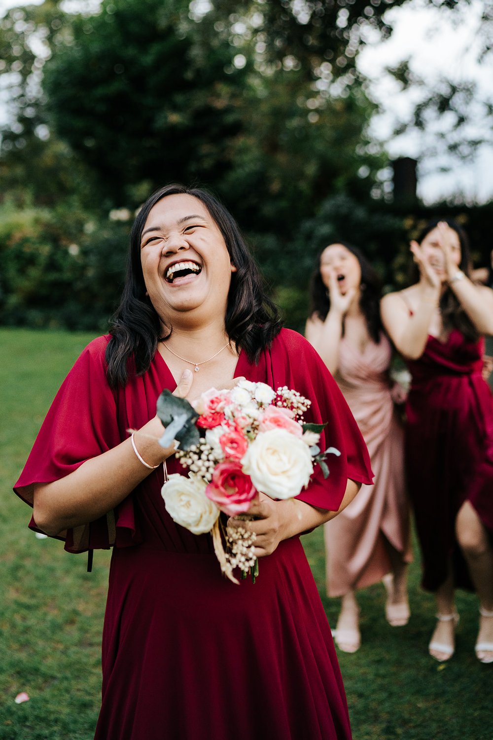 Bride's friend who caught the bouquet is best man's girlfriend. She laughs and smiles!
