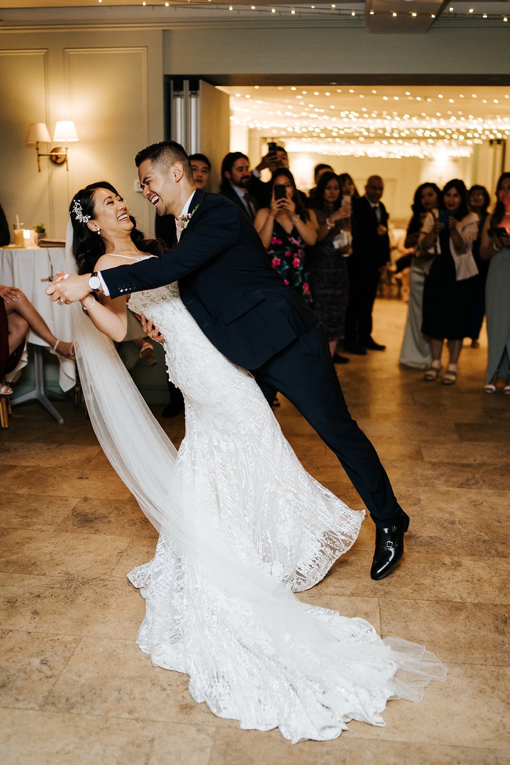 Groom dips bride slightly backwards during first dance 