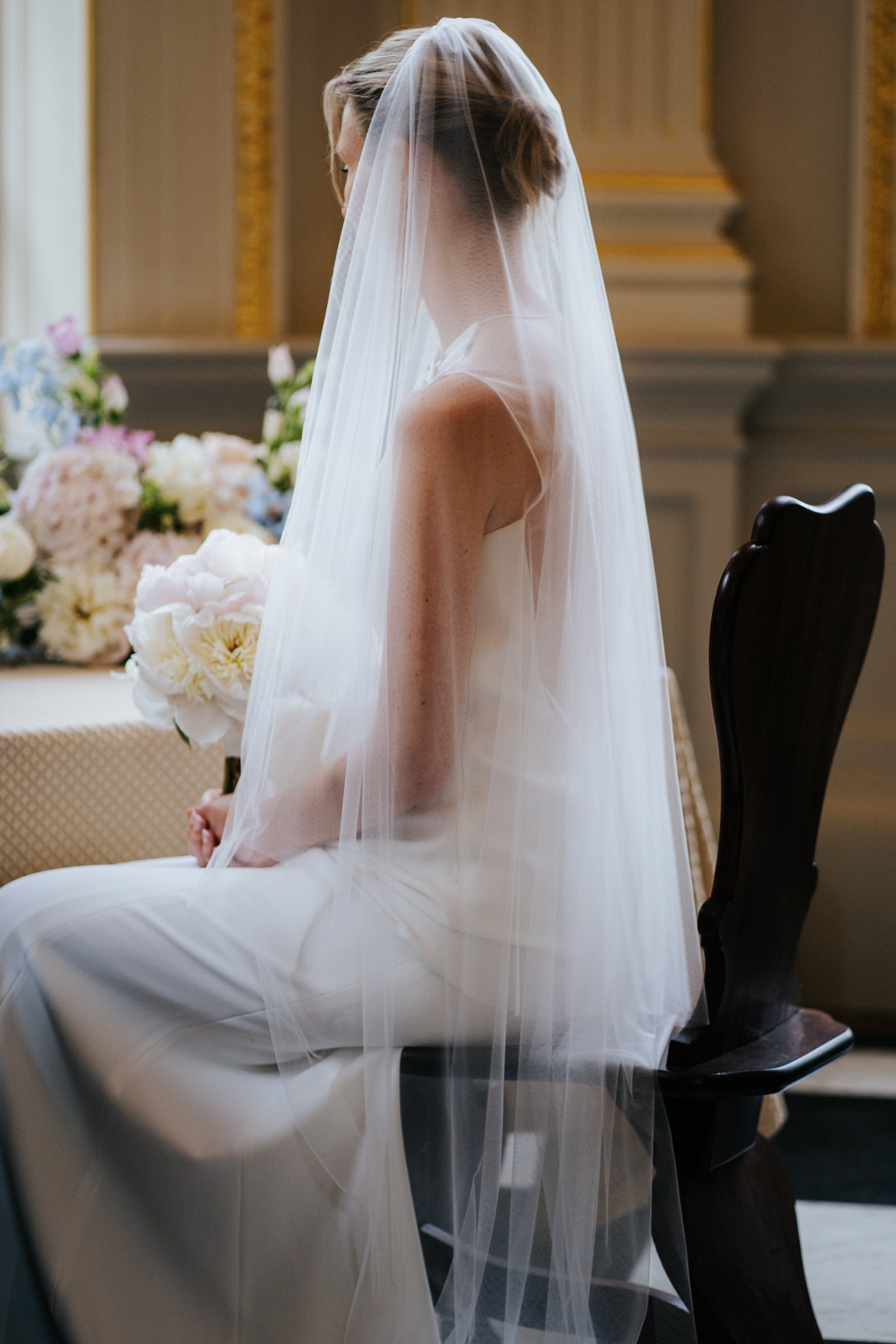Elegant photograph of bride's veil resting on her shoulders as she sits during Orleans House Gallery wedding