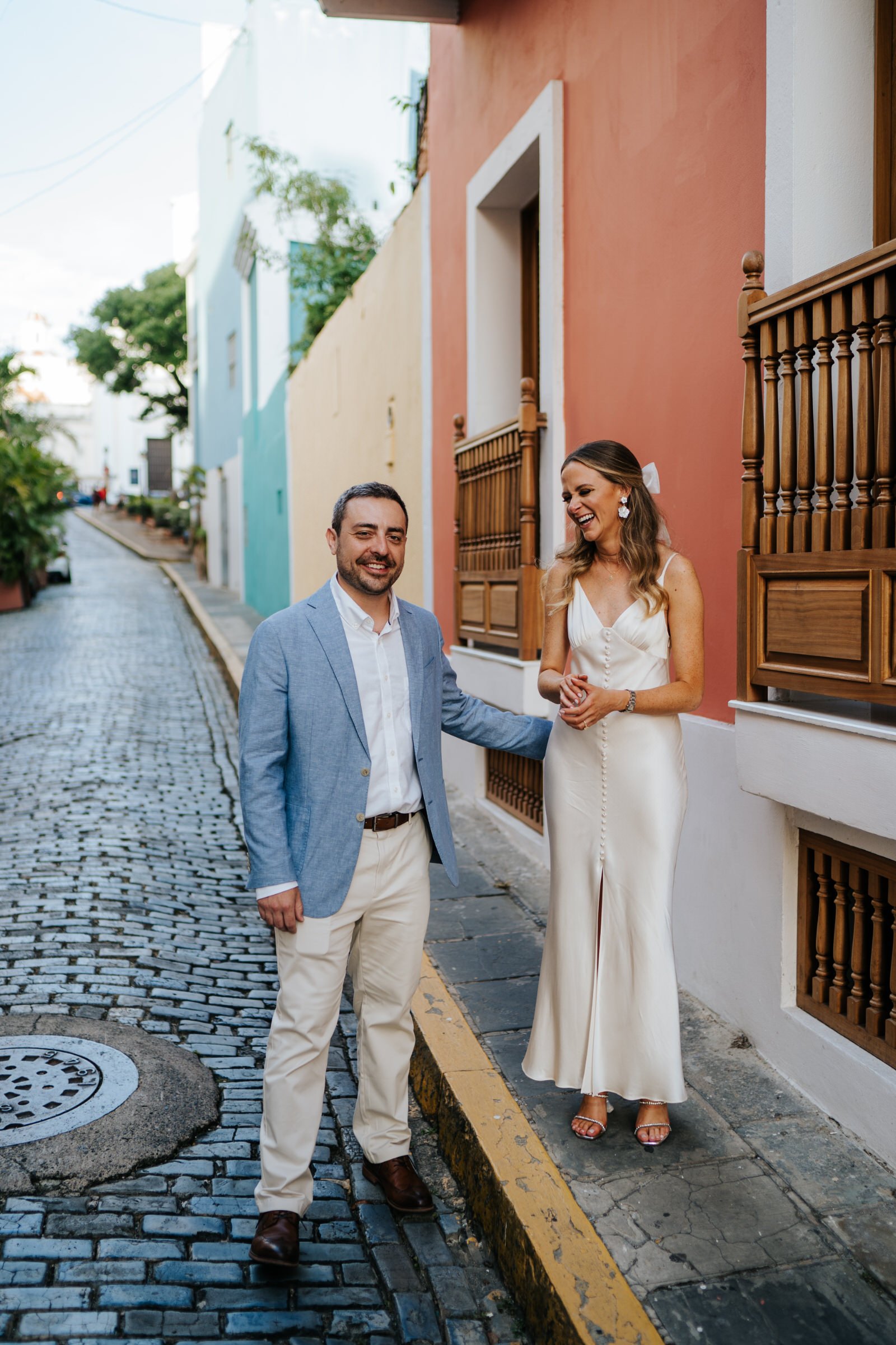 Bride and groom walking down the cobbled streets of Old San Juan share a spontaneous moment of laughter with each other