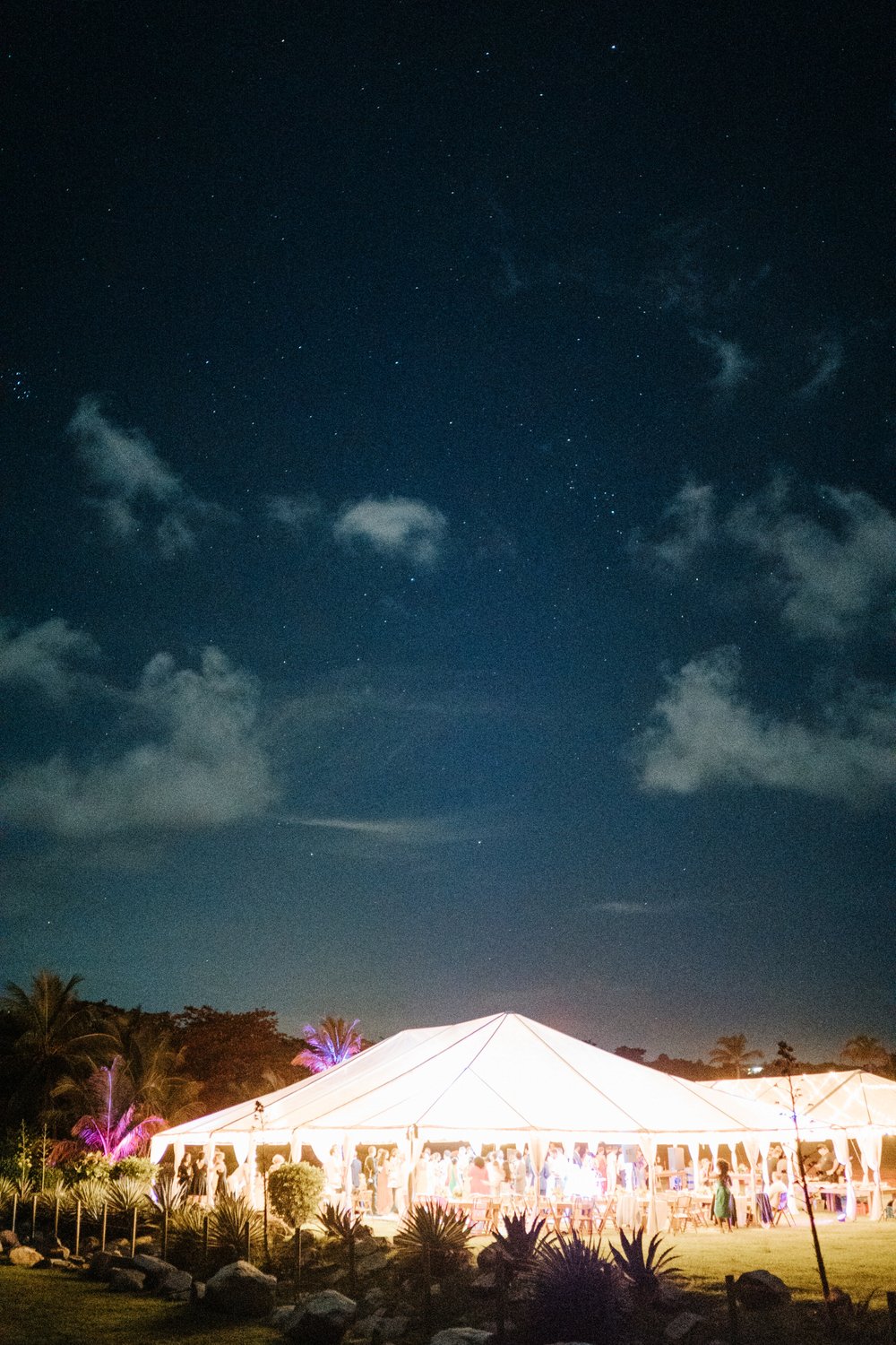 Long exposure night-time capture of marquee fully lit up as stars sparkle in the sky during beachfront wedding in Puerto Rico