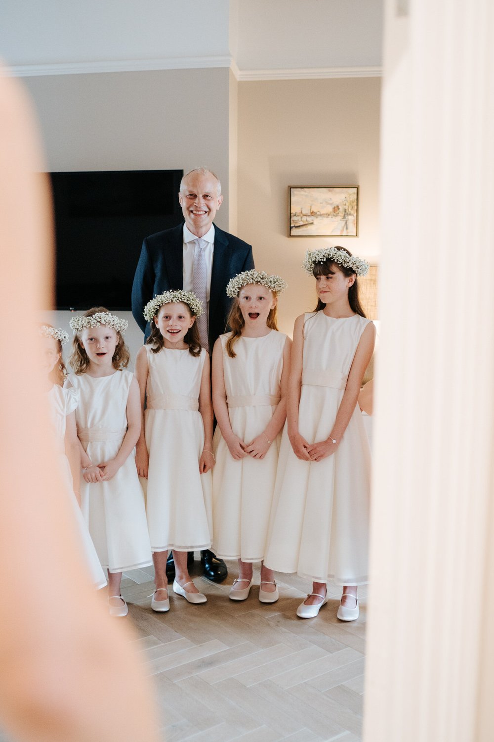 Five little bridesmaids and bride's brother see her in her wedding dress for the first time and cannot contain their joy and excitement