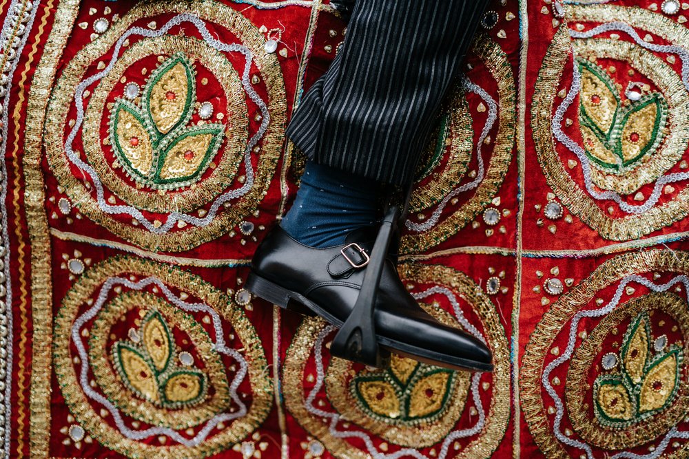 Textures of a horse's decoration for Indian wedding Bahrat as groom's foot rests in the stirrup