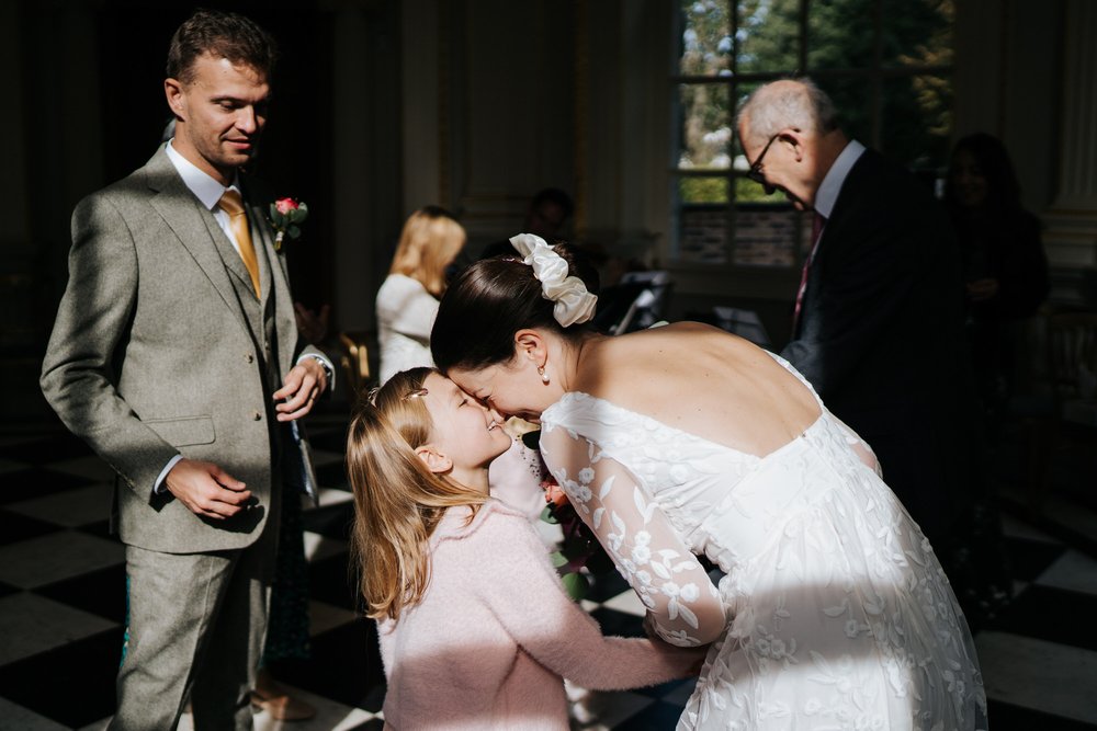 Bride nuzzles her niece in gorgeous light inside Orleans House Gallery's Octagon Room