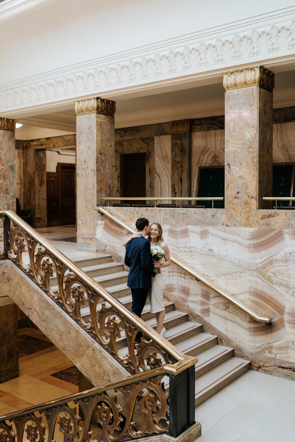Bride and groom take a moment to embrace each other on the stairs of Wandsworth Town Hall