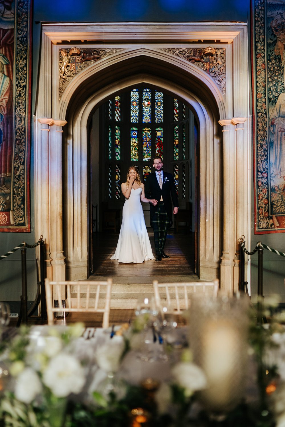 Bride and groom are both in awe as they see the decoration inside Hampton Court Palace's Great Hall for the very first time