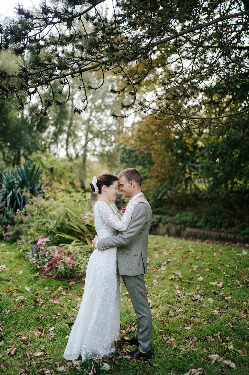Bride and groom touch their foreheads together in tender moment during wedding at Orleans House Gallery in the Autumn