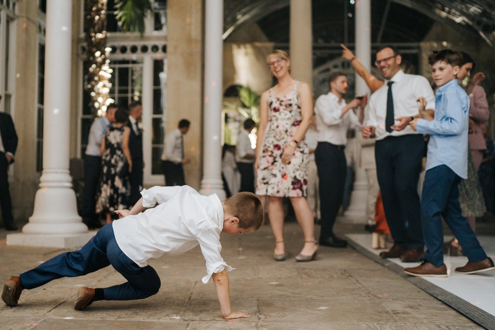 Young boy breakdances as his parents laugh and smile in the background