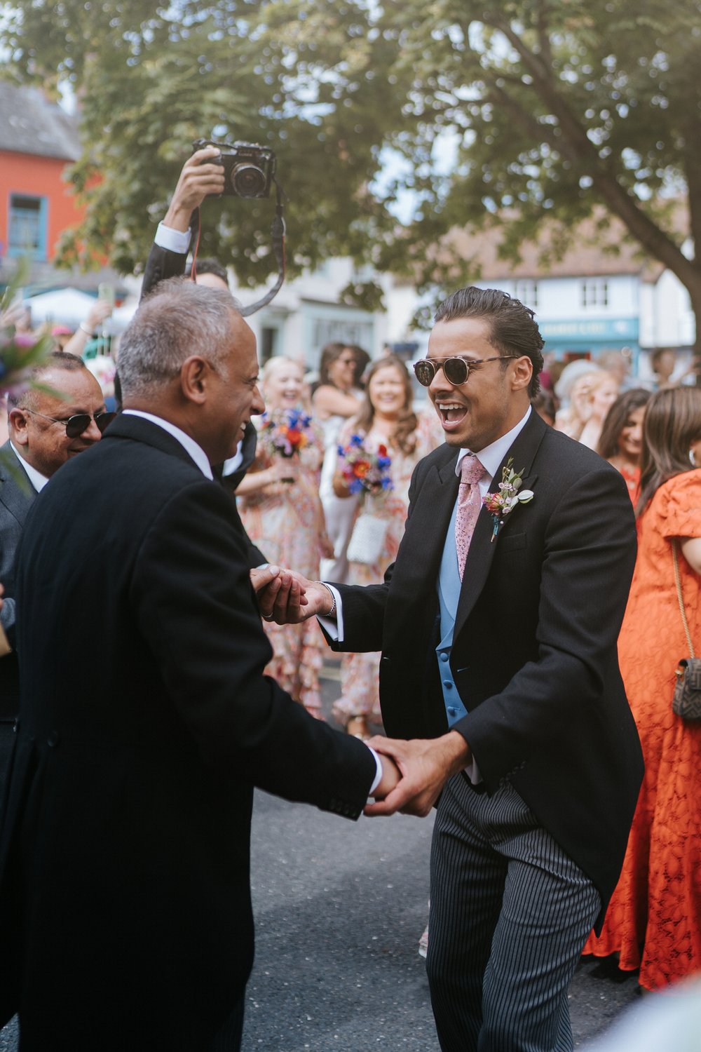 Bride's brother and father share a moment of joy as they dance during wedding day baraat