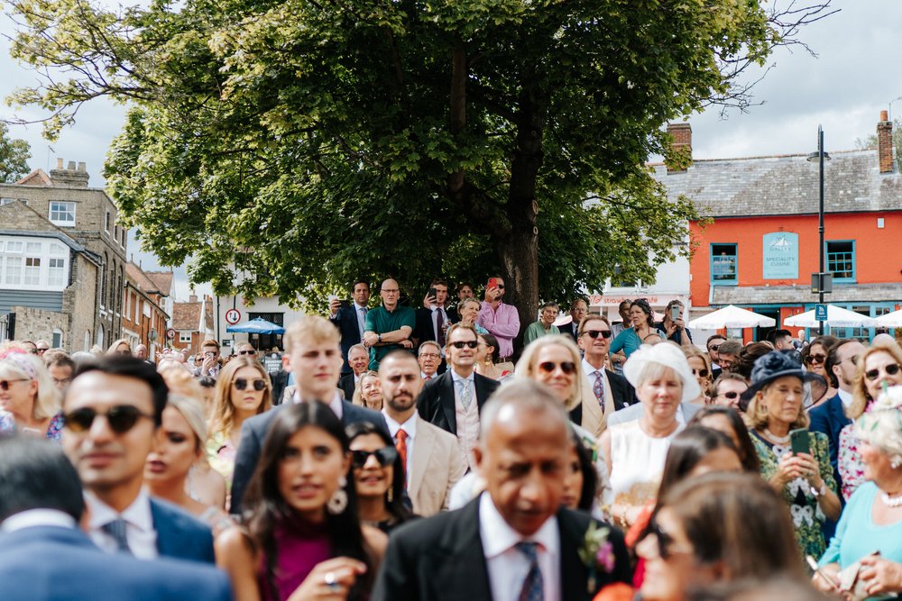 Wide photograph of the wedding guests gathered and enjoying the baraat in Woodbridge town square