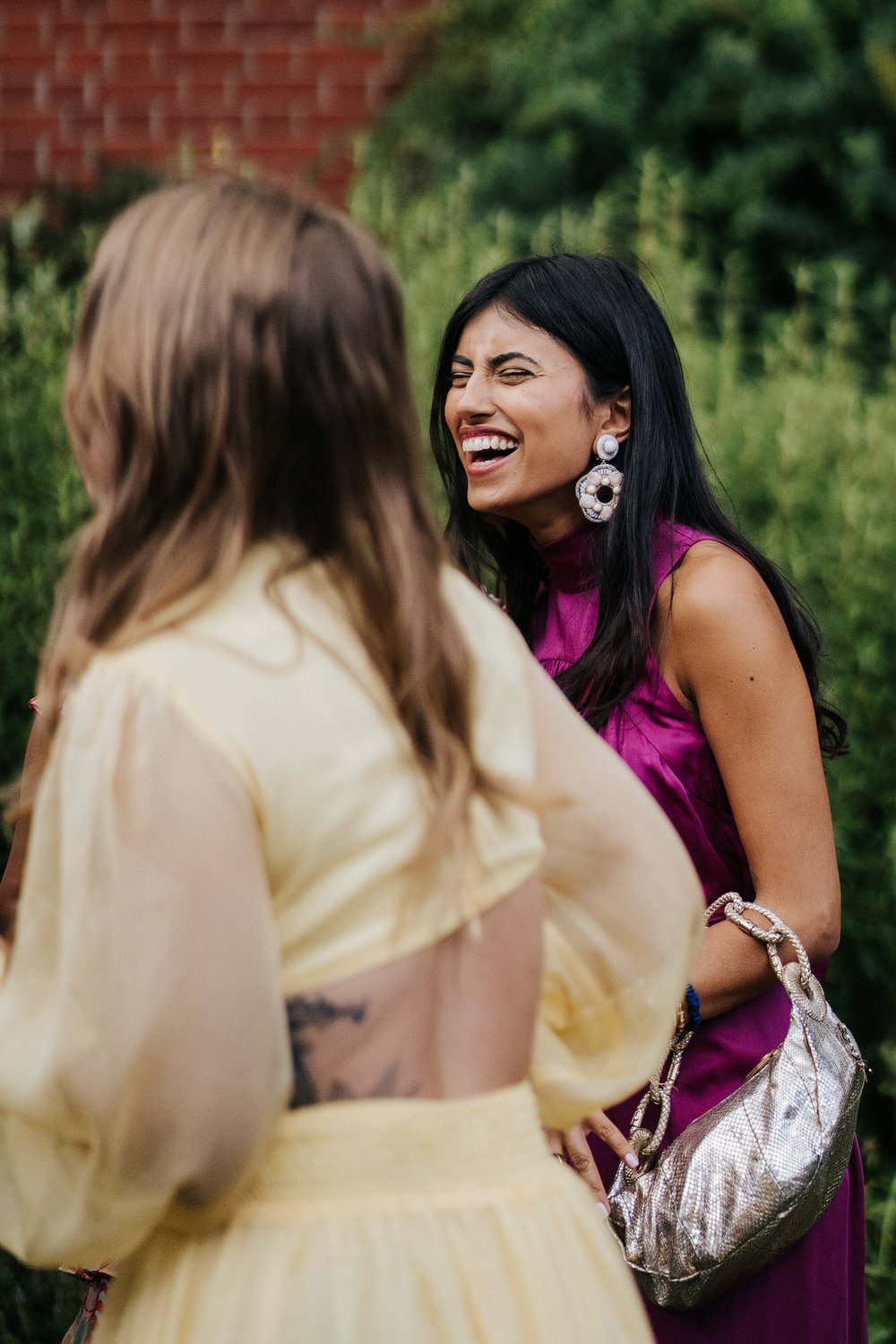 Candid of wedding guests laughing and enjoying herself
