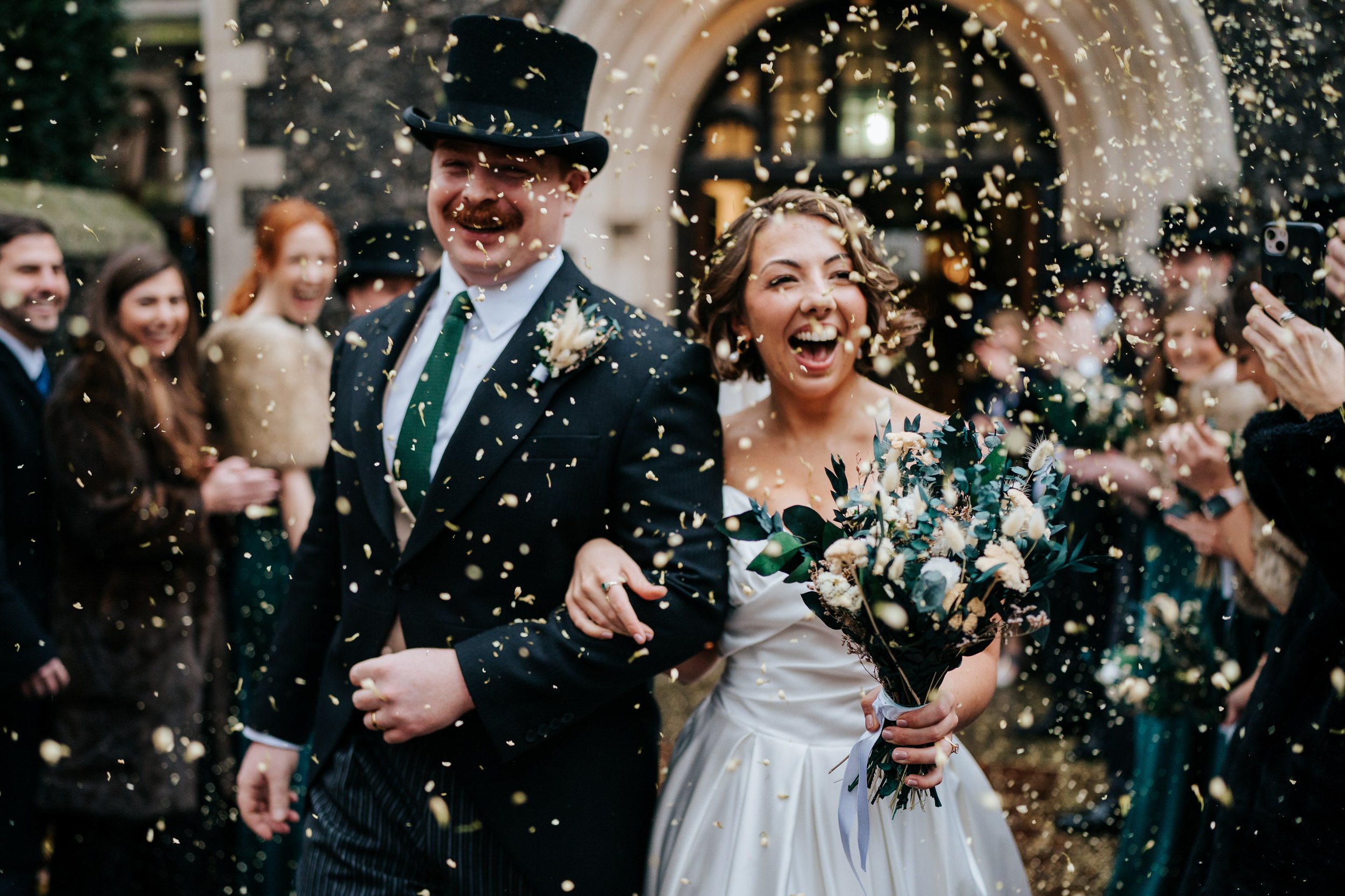 Bride and groom, dressed regally, exit St Bartholomew The Great in London after church ceremony