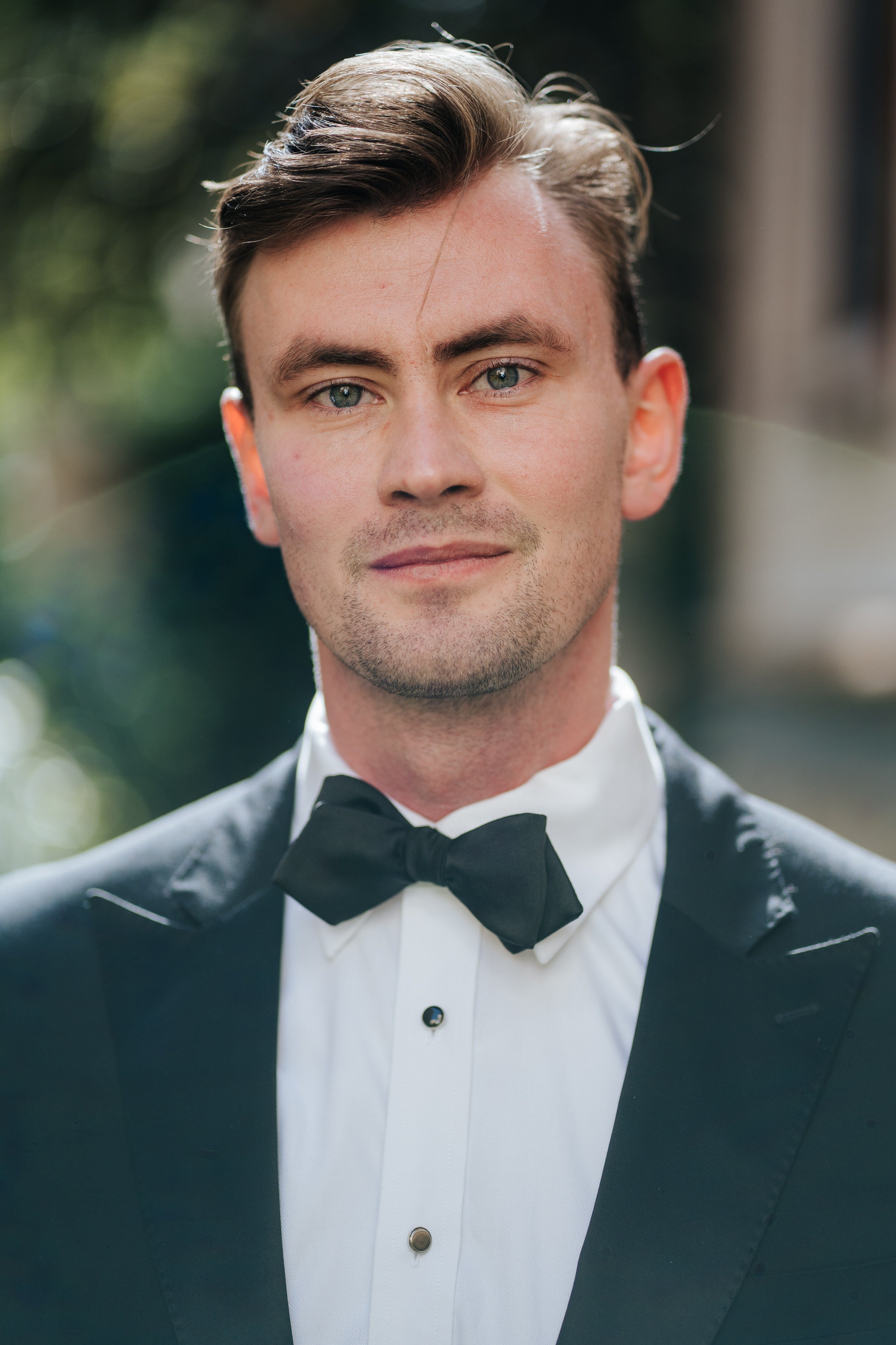 Tender portrait of groom before ceremony as a beautiful lens flare cuts through his vision in Seville wedding