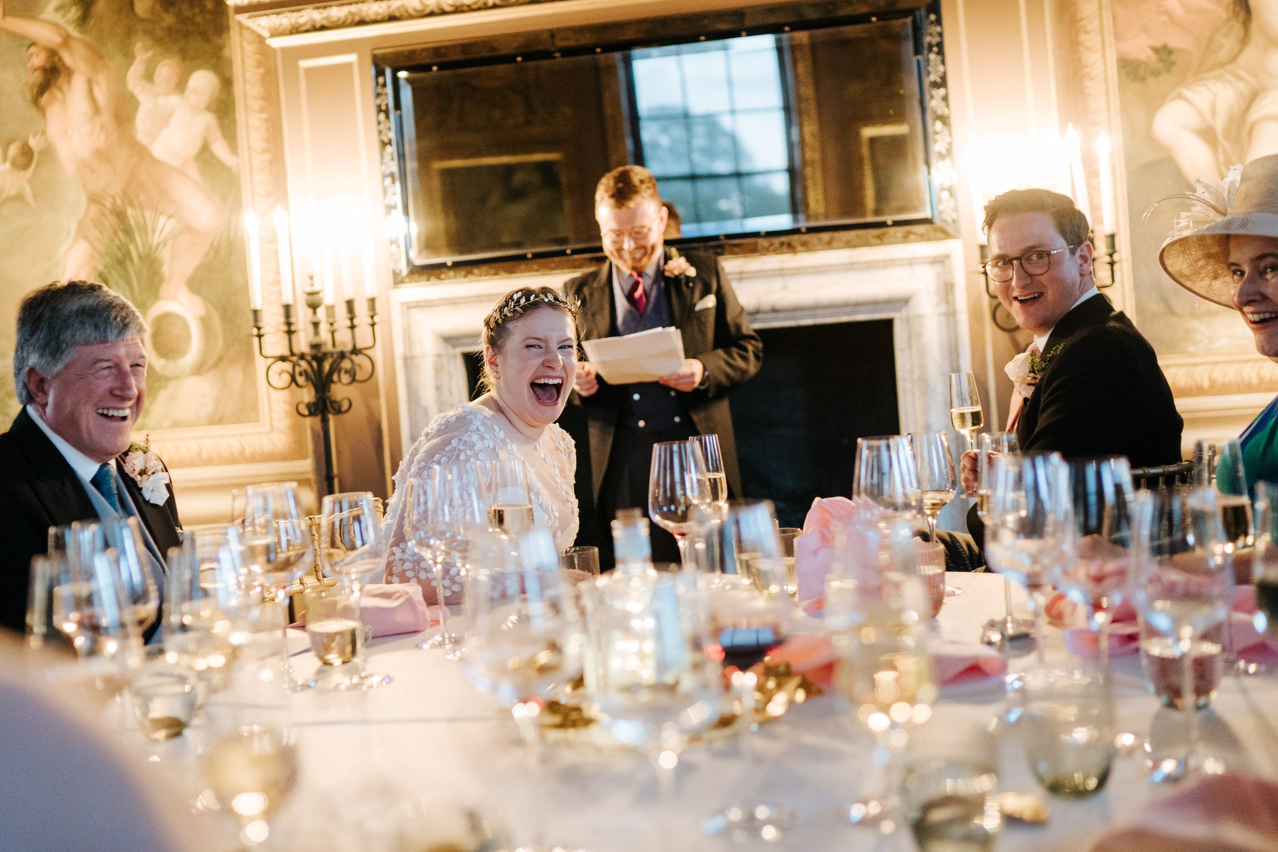 Intimate photograph of bride, groom and her parents reacting to speech at Hampton Court Palace