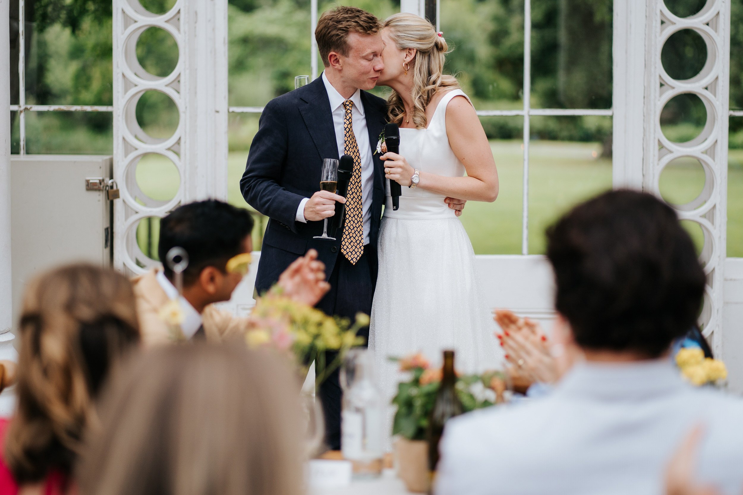 Bride and groom embrace in a moment of tenderness during Syon Park wedding speeches