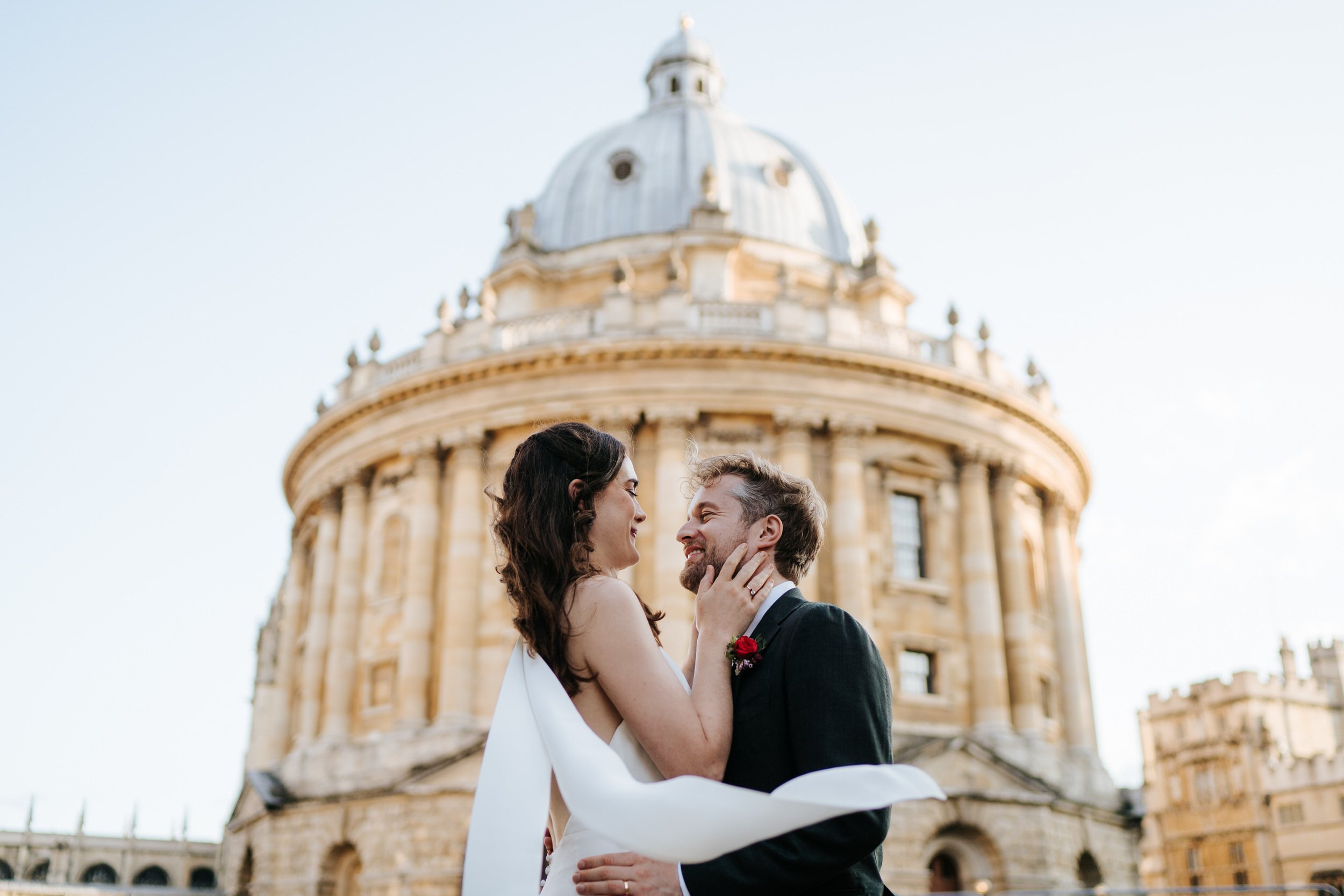 Bride and groom pose in front of Radcliffe Camera in Oxford during epic wedding photograph
