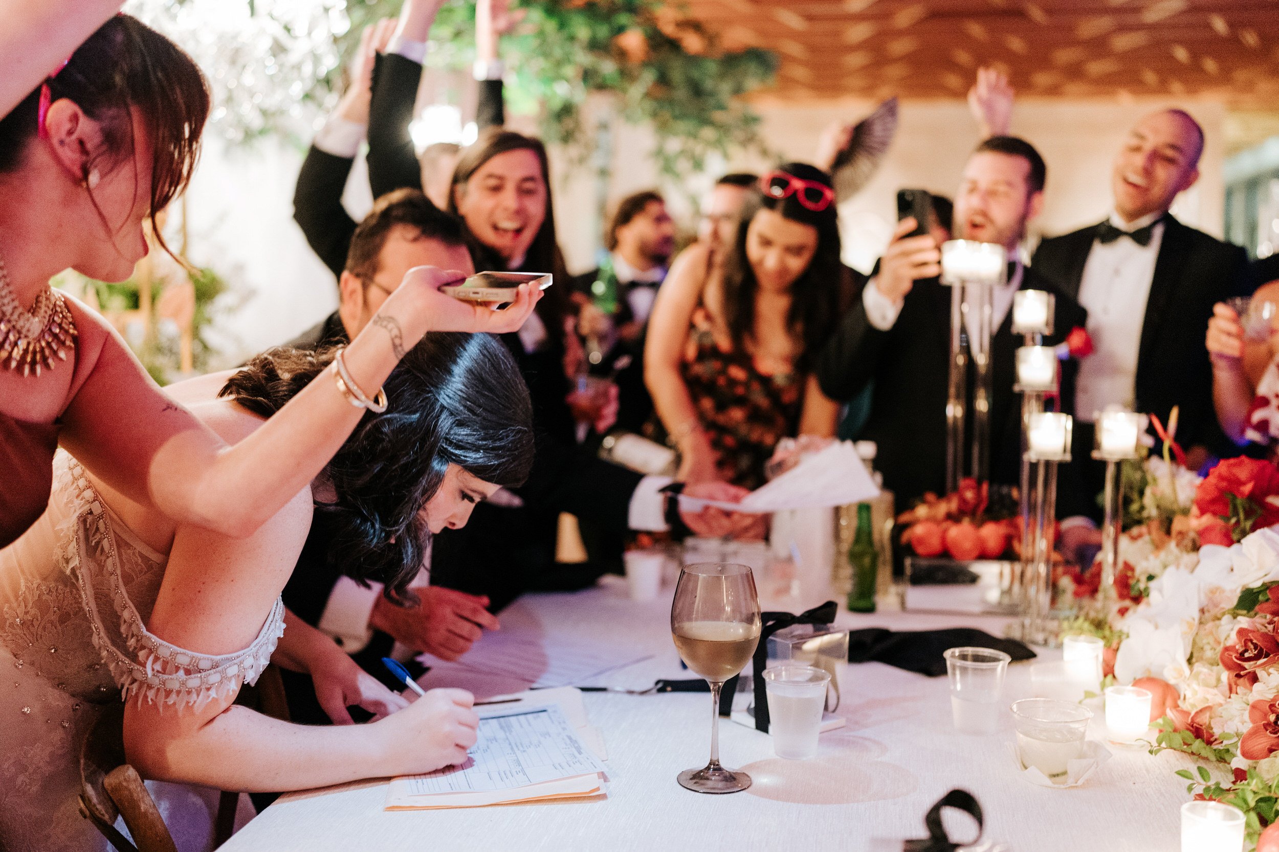 Bride signing her wedding license during party as guests pour Pitorro during Puerto Rico Christmas wedding