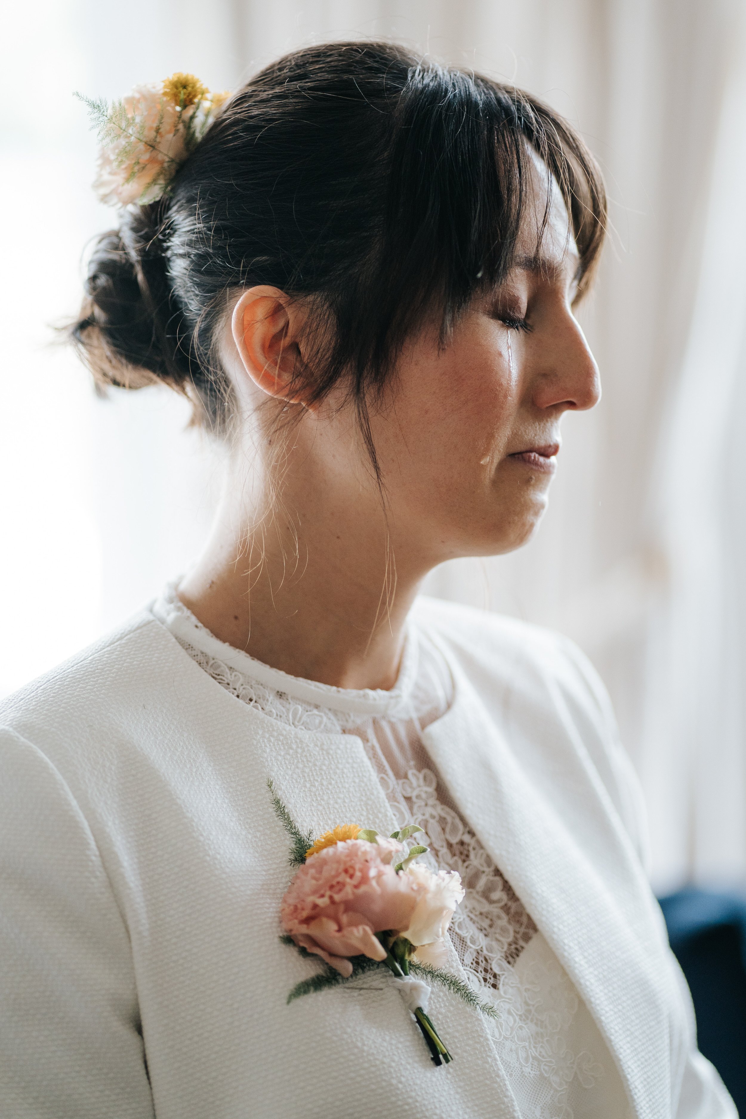 Close-up photograph of bride crying as she waits for the ceremony to begin